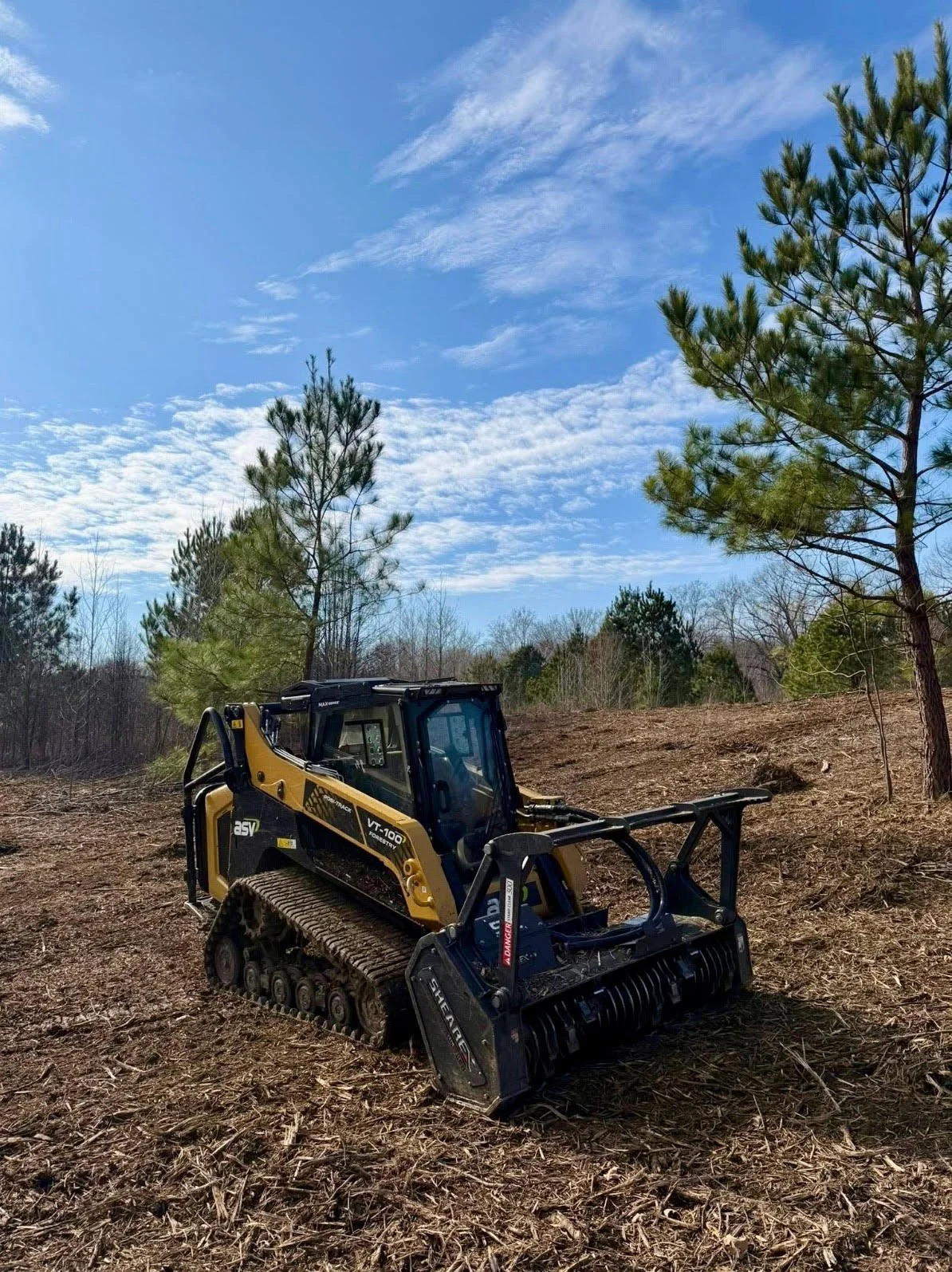 Compact track loader performing eco-friendly forestry mulching and land clearing on a wooded property in Germantown, TN.