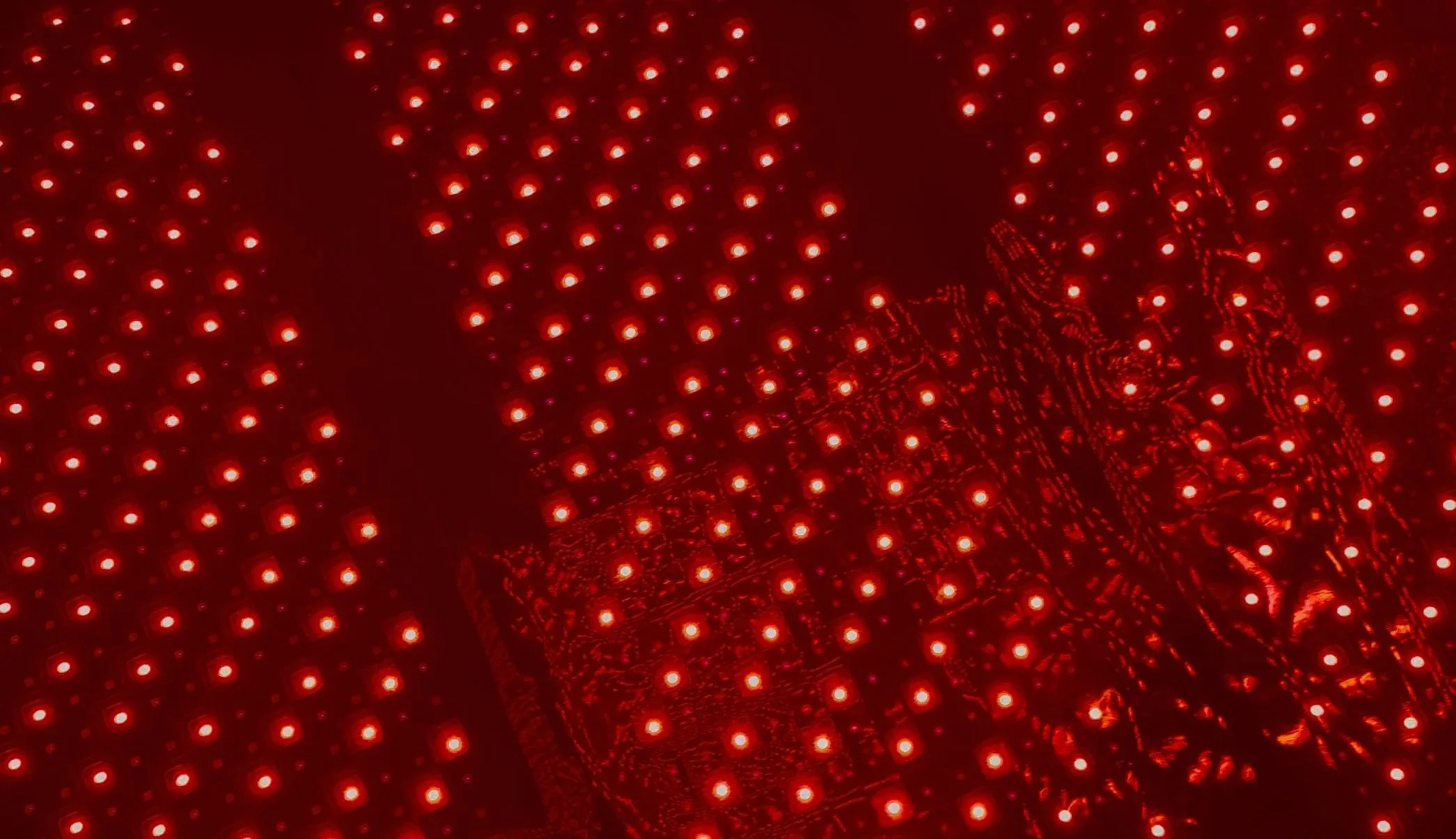 Close-up of a red LED Christmas light display with a decorative cube structure illuminated in red.