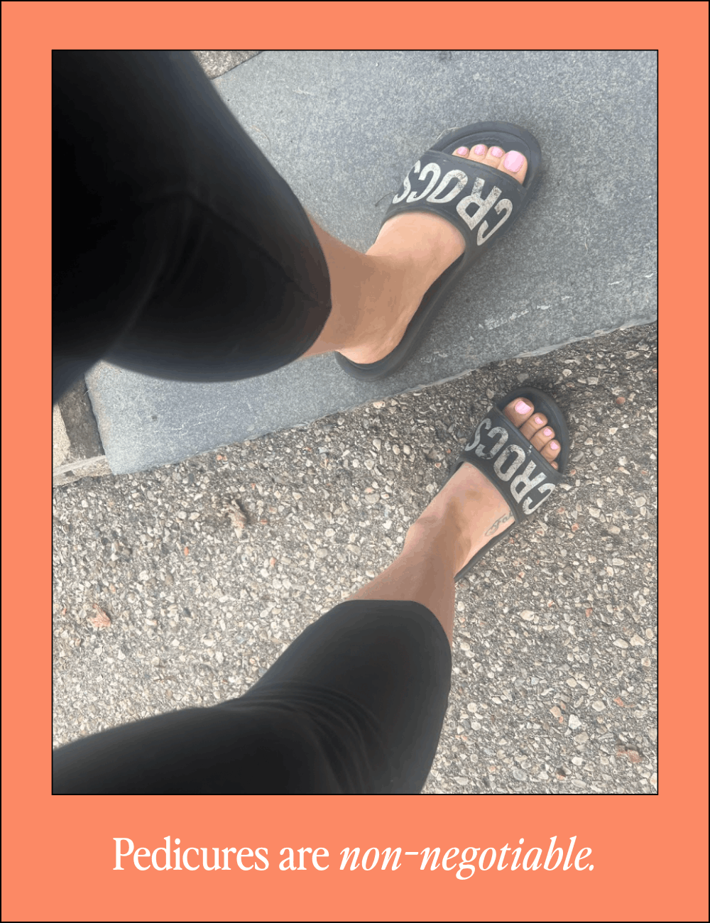 A person's feet wearing black slide sandals with the word 'CROS' visible, standing on a sidewalk near a curb.