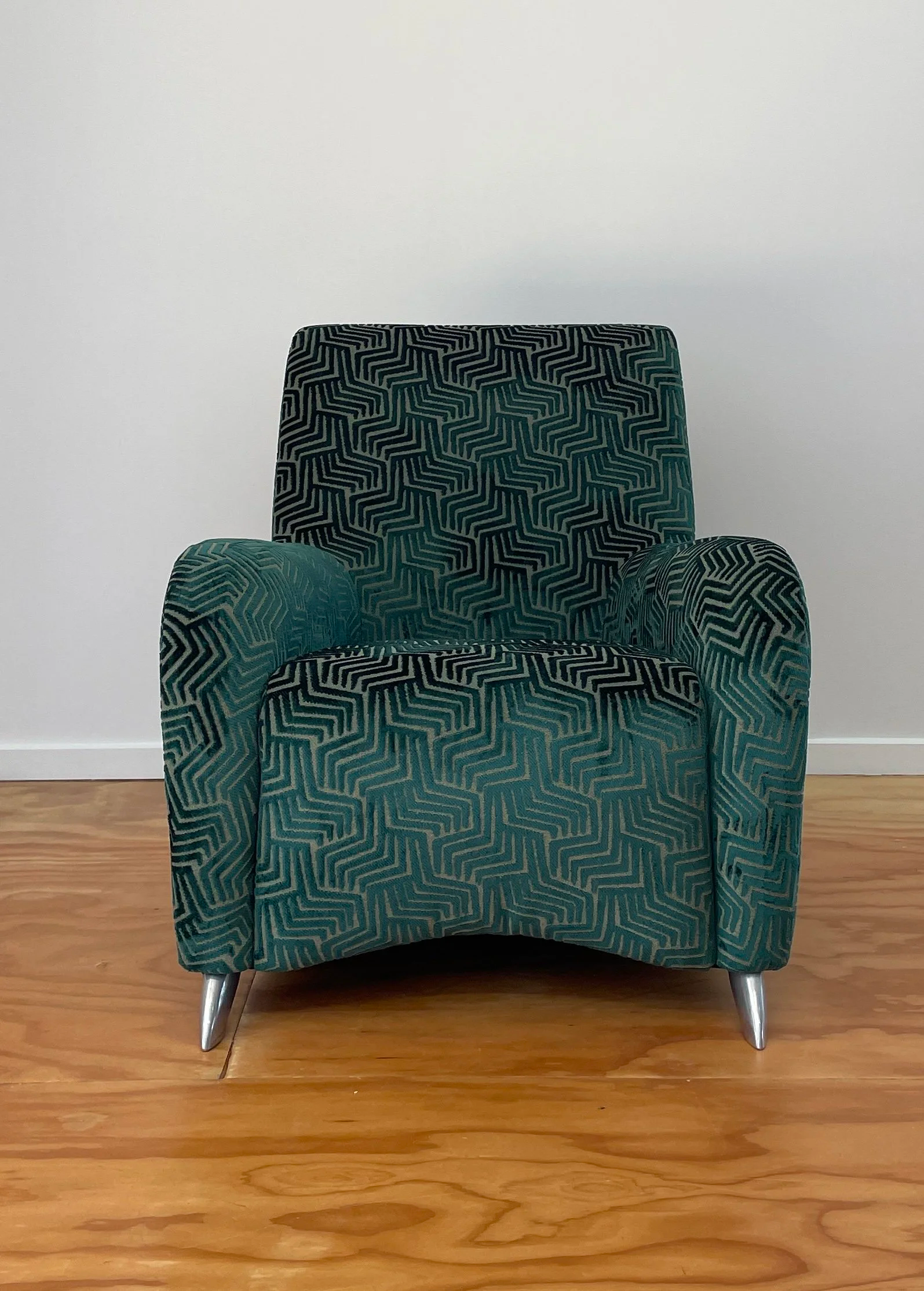 A patterned armchair with a geometric design in teal and black