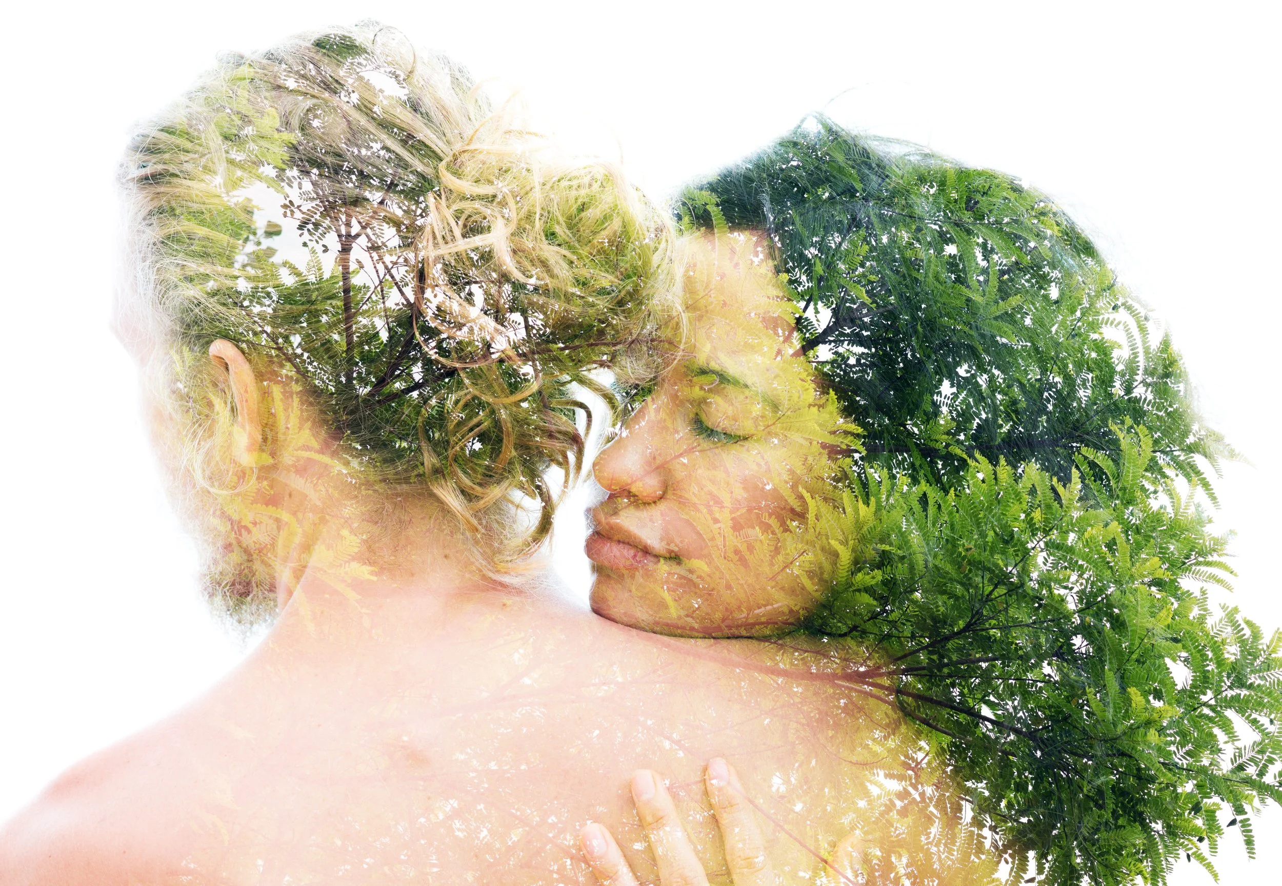 A double exposure image of a woman and a man with their foreheads and noses touching, superimposed with green leafy trees and foliage.