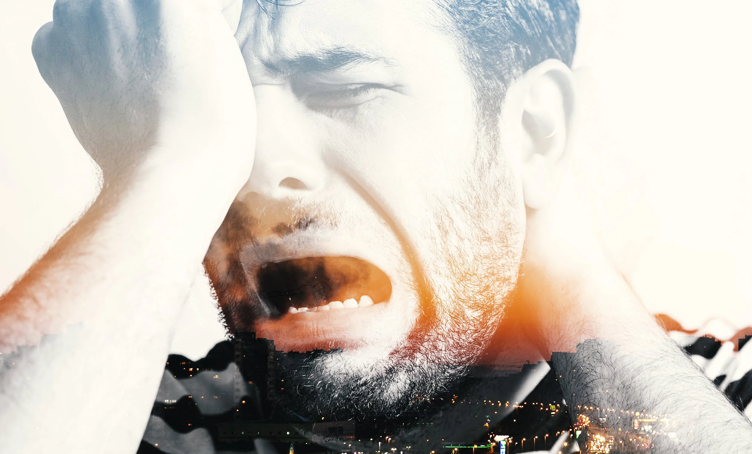 A black and white close-up of a distressed man holding his head with one hand, with a cityscape overlay at the bottom.