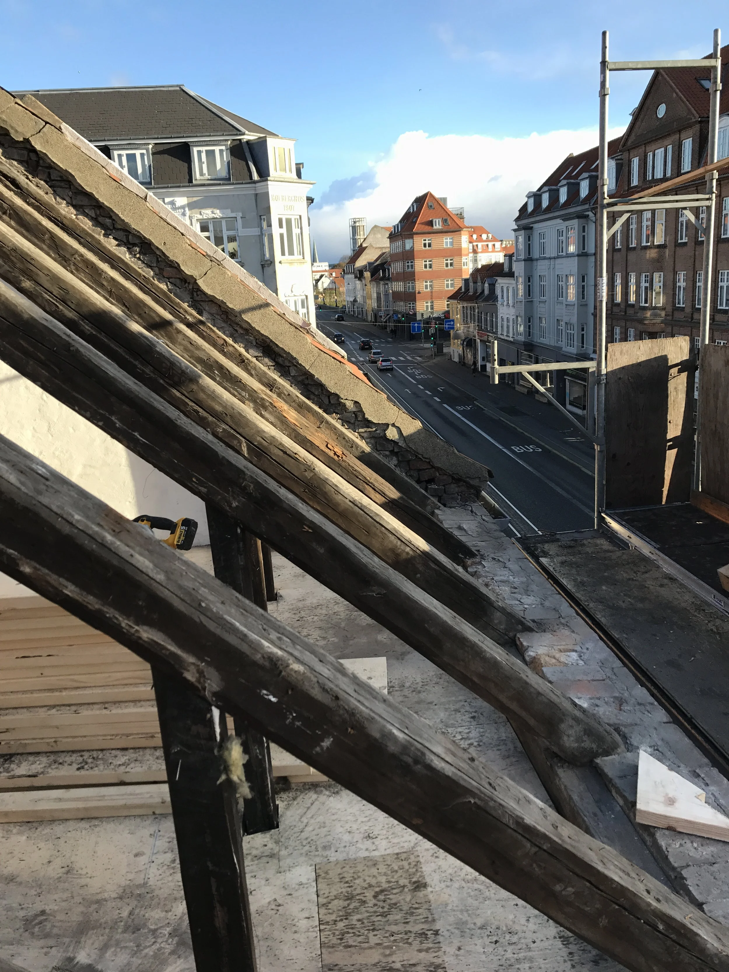 En udsigt over byens gader med gamle, farverige bygninger under en blå himmel.