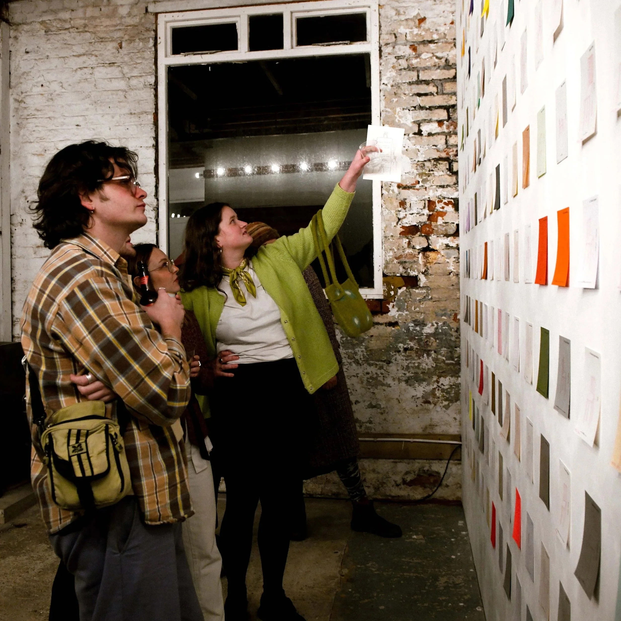 Photograph from a private view exhibition showing 252 chair drawings on display, with visitors viewing the artwork in a gallery space.