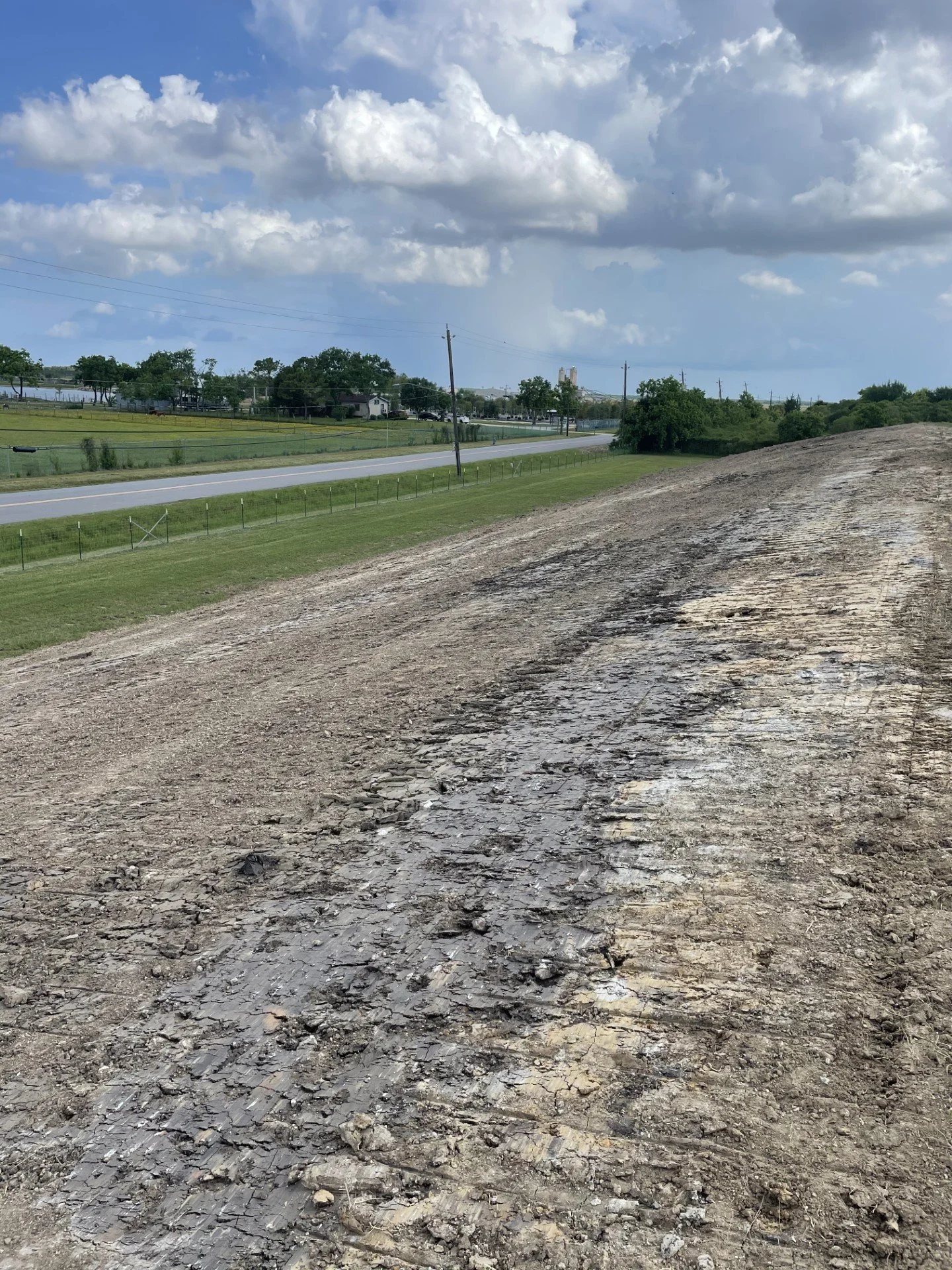 Excavation and grading work on a sloped site in Navasota showing soil preparation and land leveling for construction near a roadway