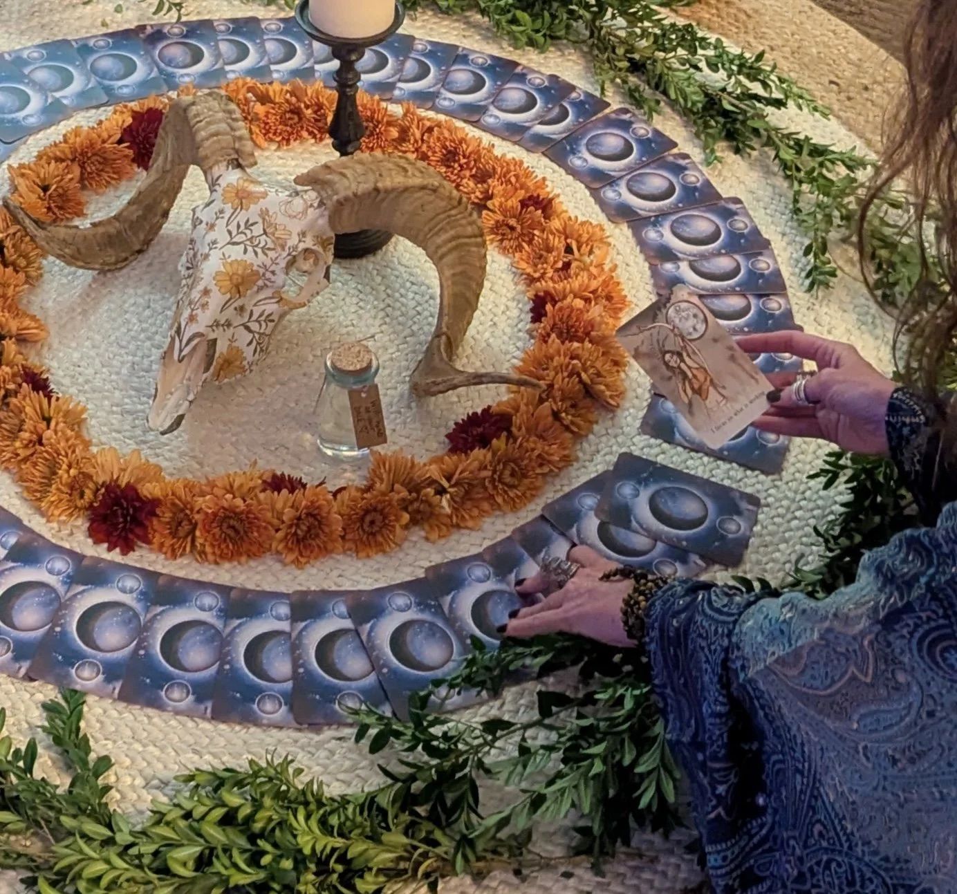 Altar with painted ram skull, flowers, and oracle cards