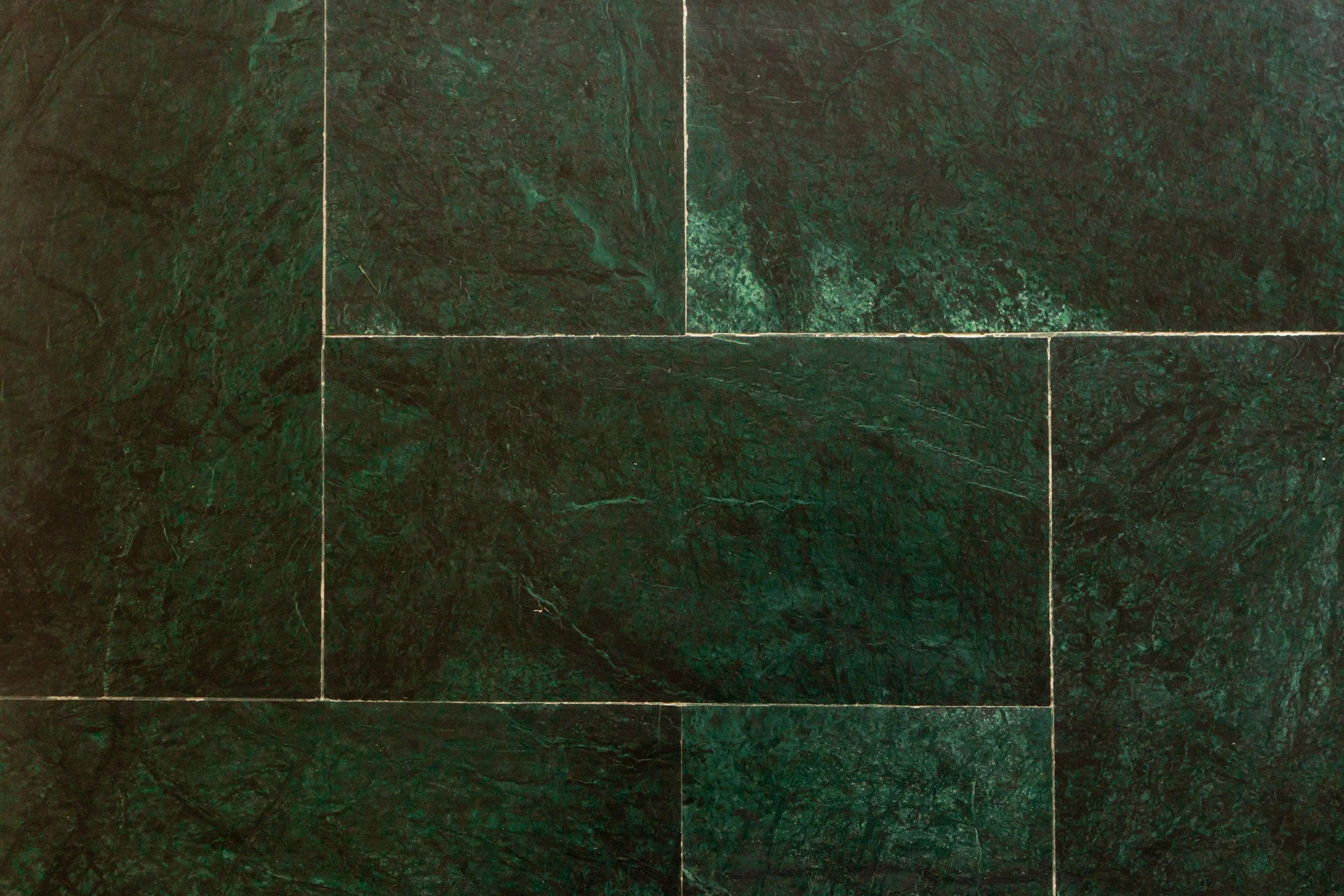 Dark green marble floor tiles with white grout lines.