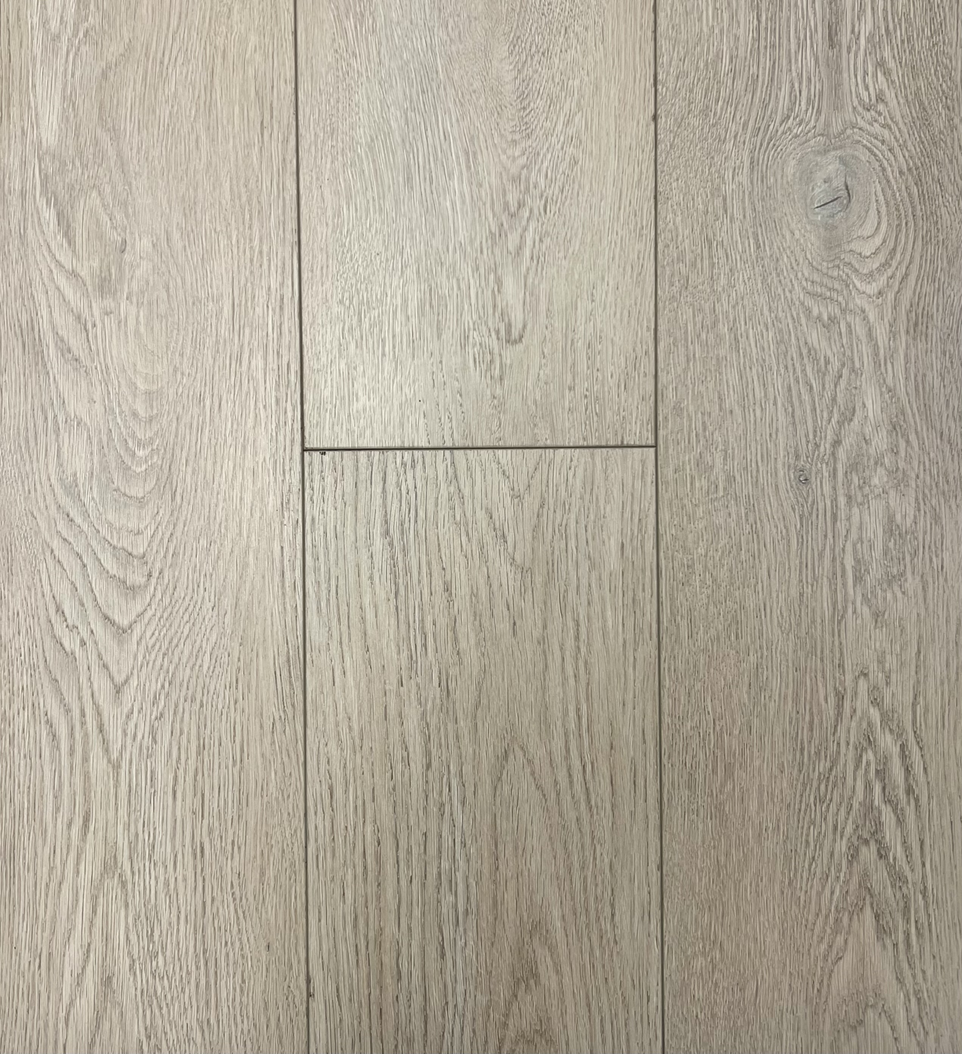 A close-up of light-colored wooden floorboards with a natural wood grain pattern.