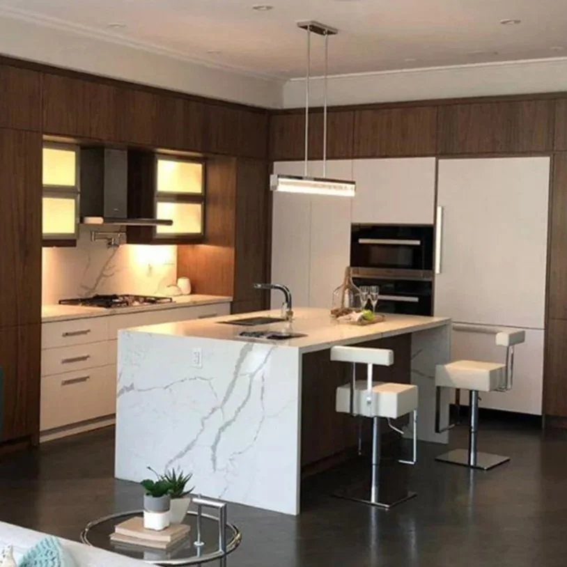 Modern kitchen with dark wood paneling, white marble accents, white cabinetry, a marble island with a sink, and two white bar stools.