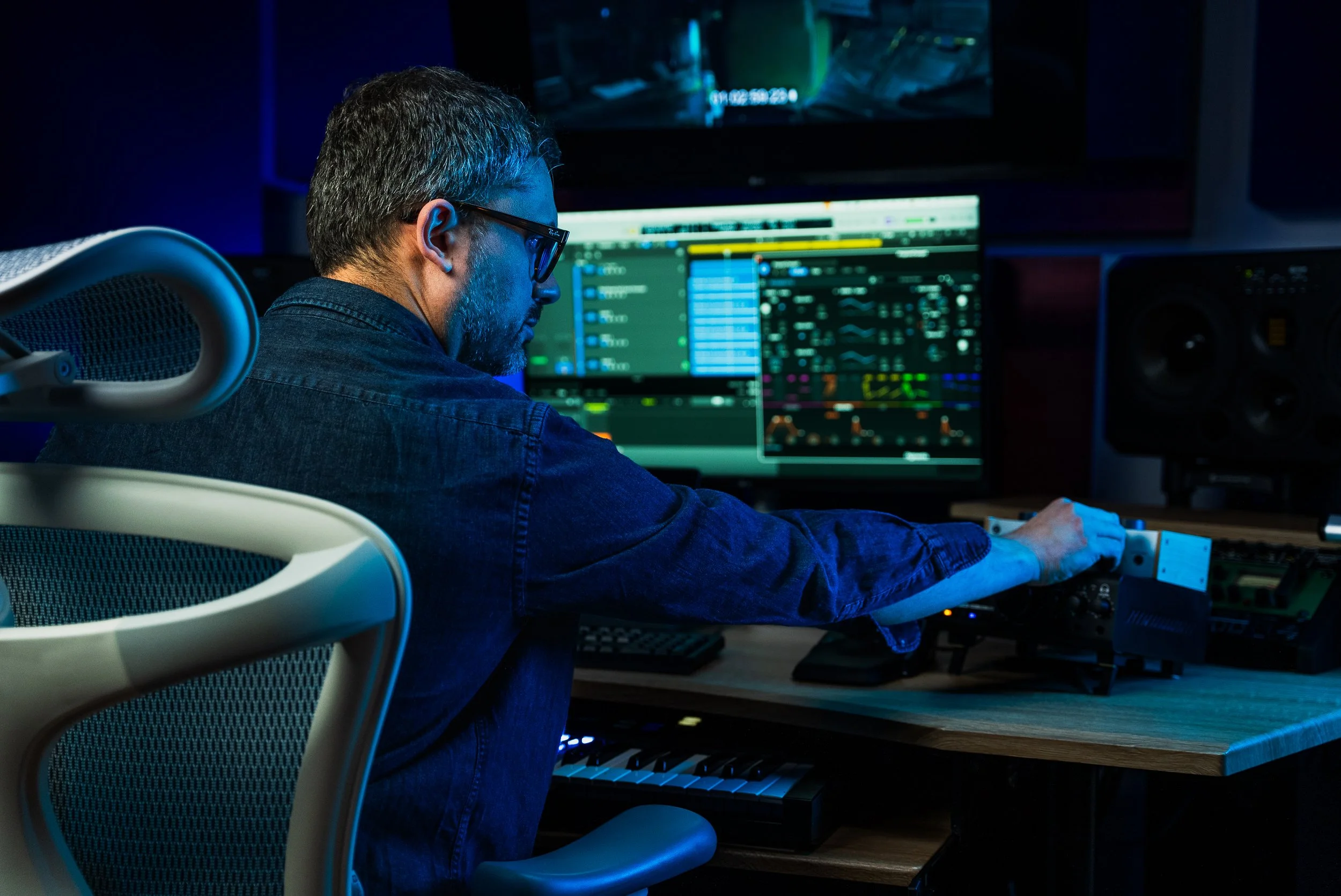 Persona in uno studio di registrazione al lavoro con apparecchiature audio digitali.