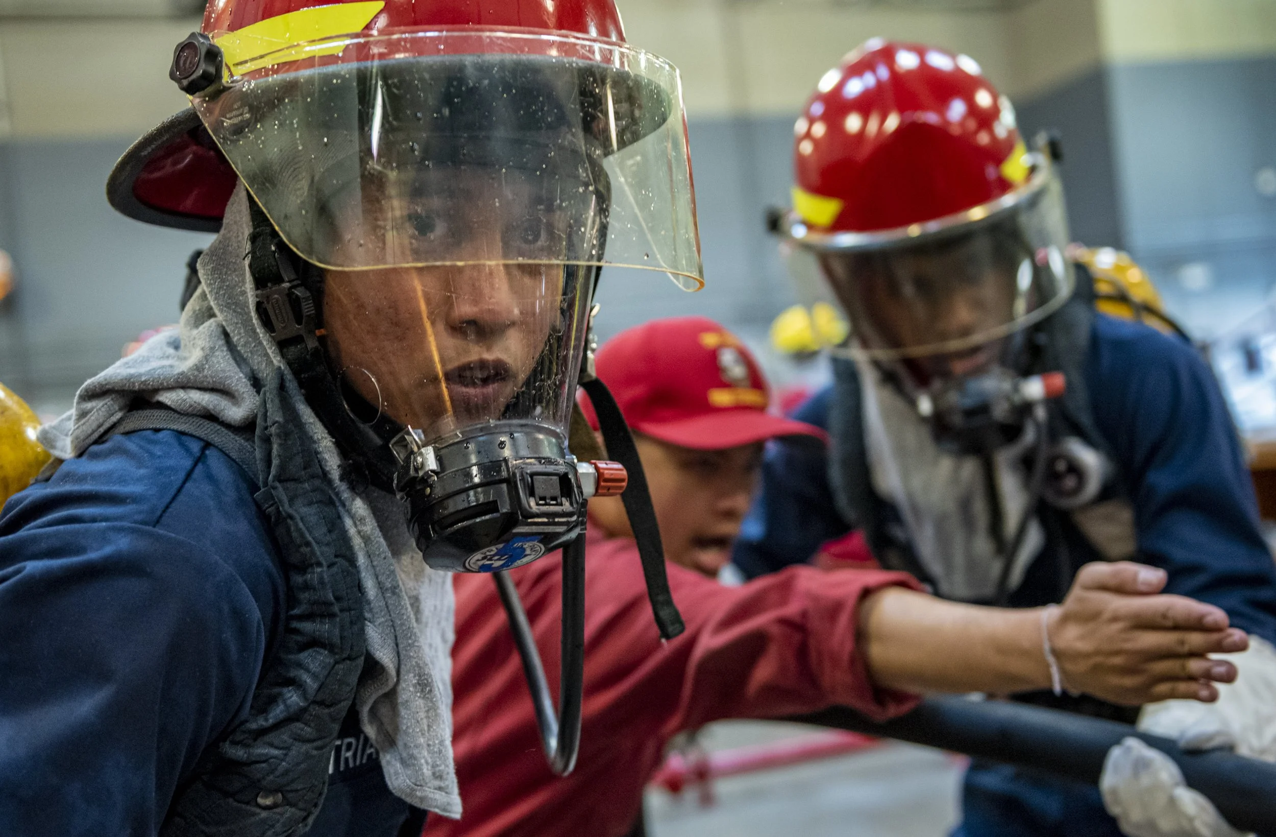 Recruits perform fire fighting and damage control techniques inside the USS Chief Fire Fighter Trainer as part of the hands-on learning at Recruit Training Command. More than 35,000 recruits train annually at the Navy's only boot camp. 