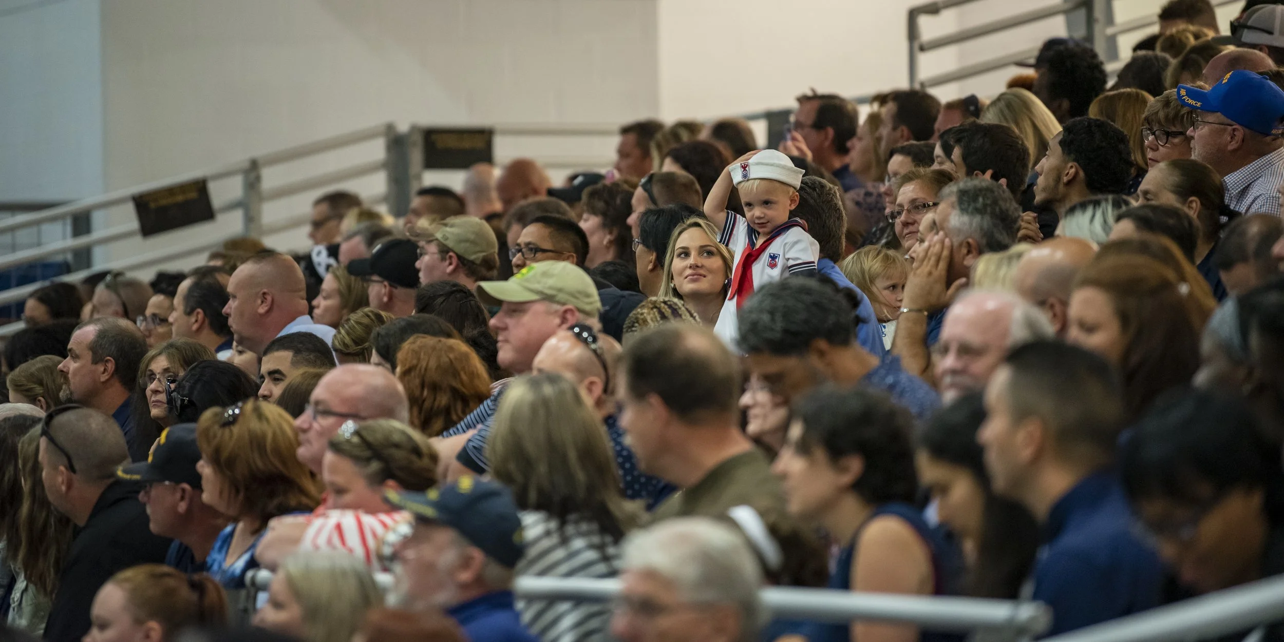 Guests observe a pass-in-review graduation ceremony inside Midway Ceremonial Drill Hall at Recruit Training Command. More than 35,000 recruits train annually at the Navy's only boot camp.
