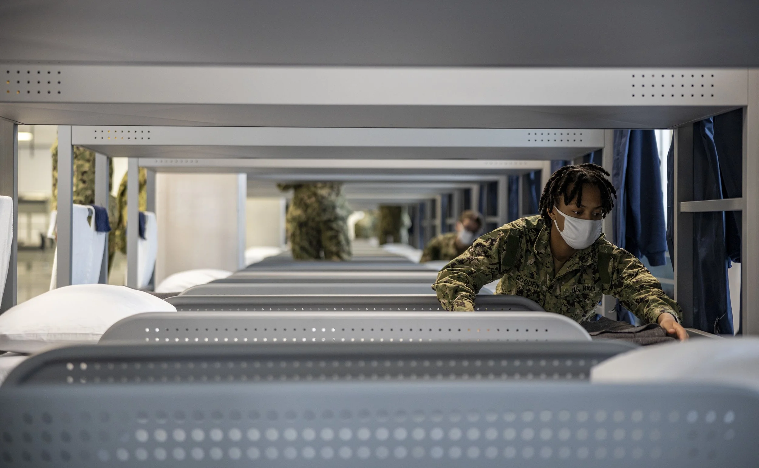 A recruit participates in a dynamic material inspection at Recruit Training Command. Regular practice and inspection of proper bunk make-up procedures, and fold-and-stow procedures emphasizes attention to detail into recruits throughout their trainin