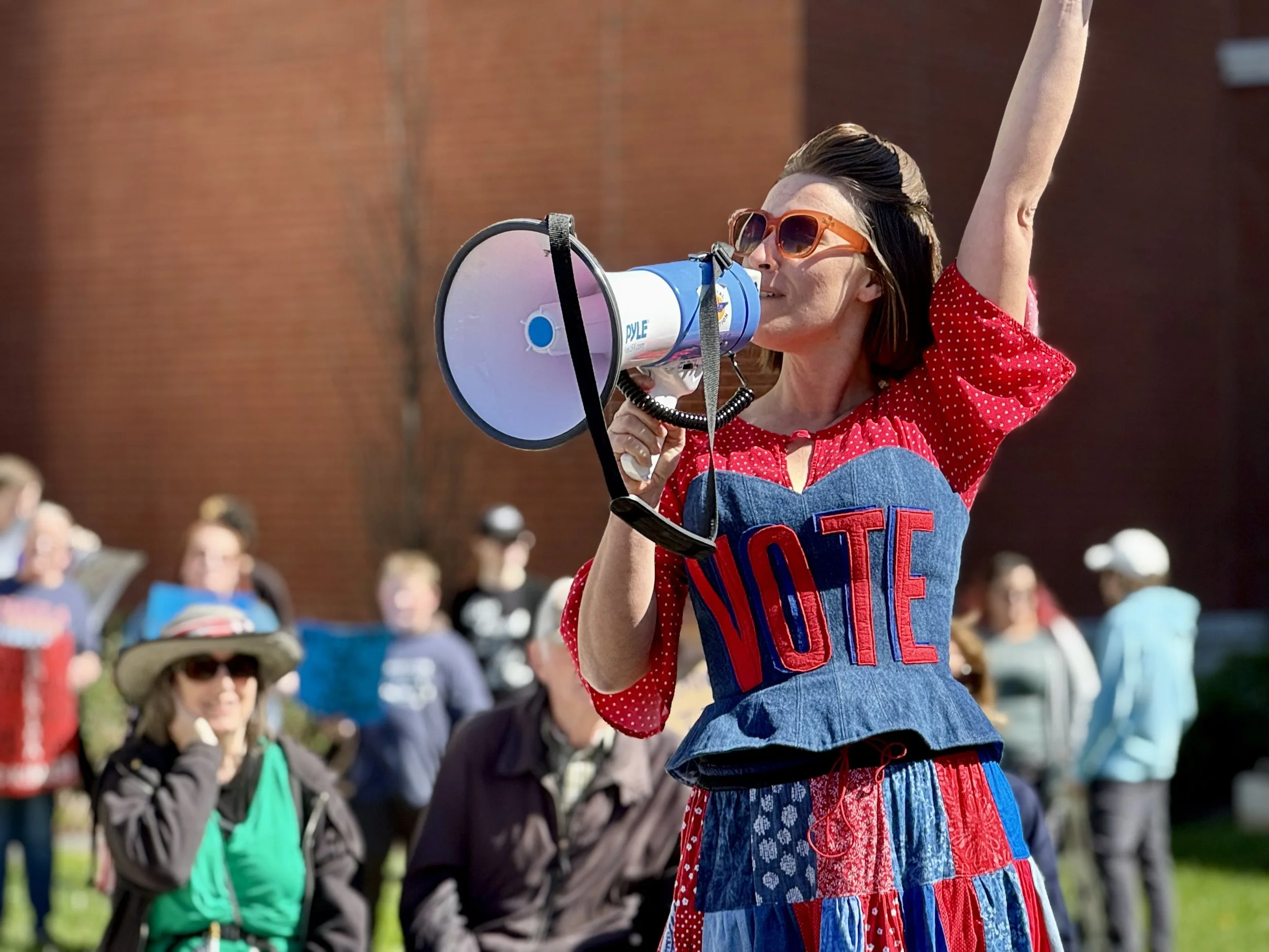 Mandy holding a megaphone with a shirt that reads "Vote"
