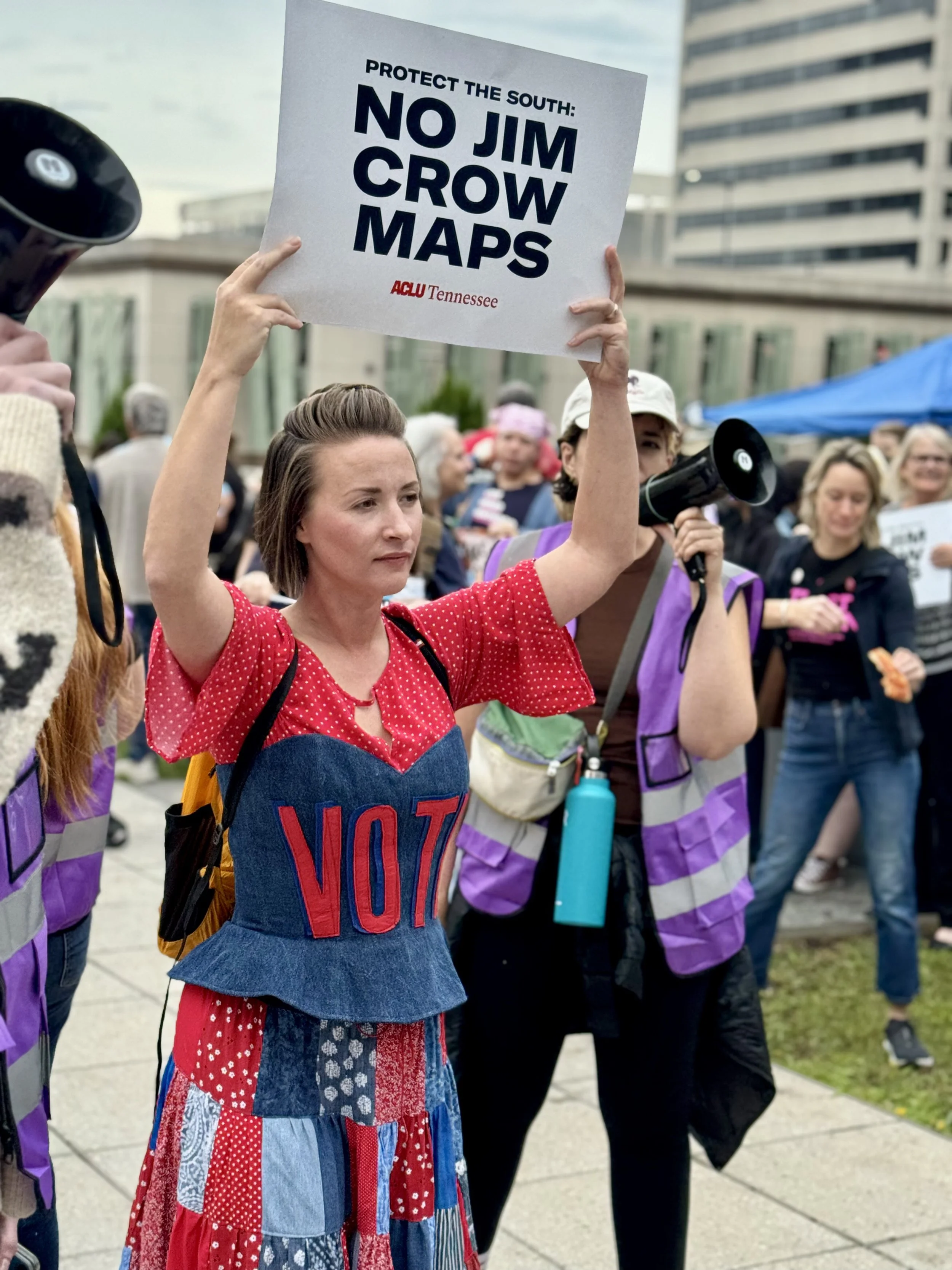 Mandy at the Capitol holding sign reading "No Jim Crow Maps"
