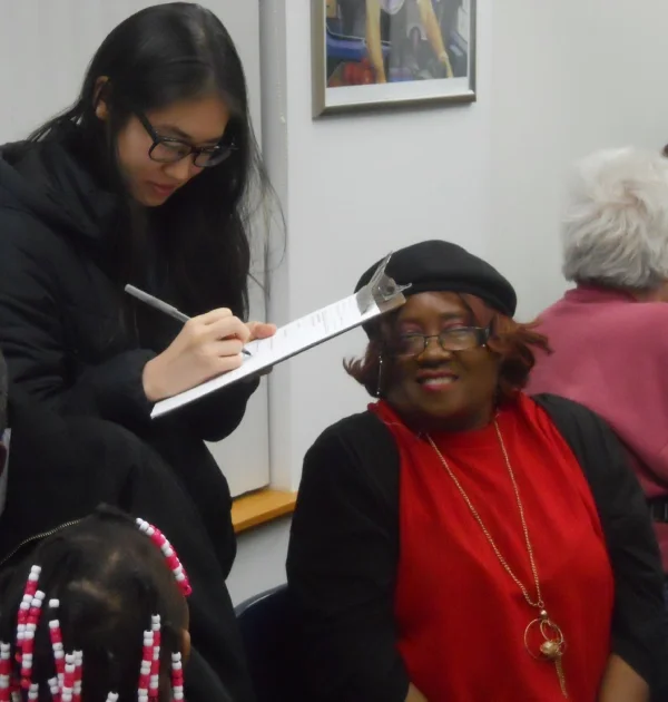 young woman writing notes on a clipboard