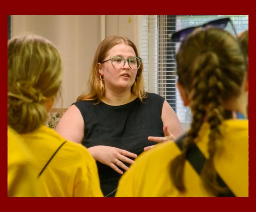 Volunteer speaking to some students
