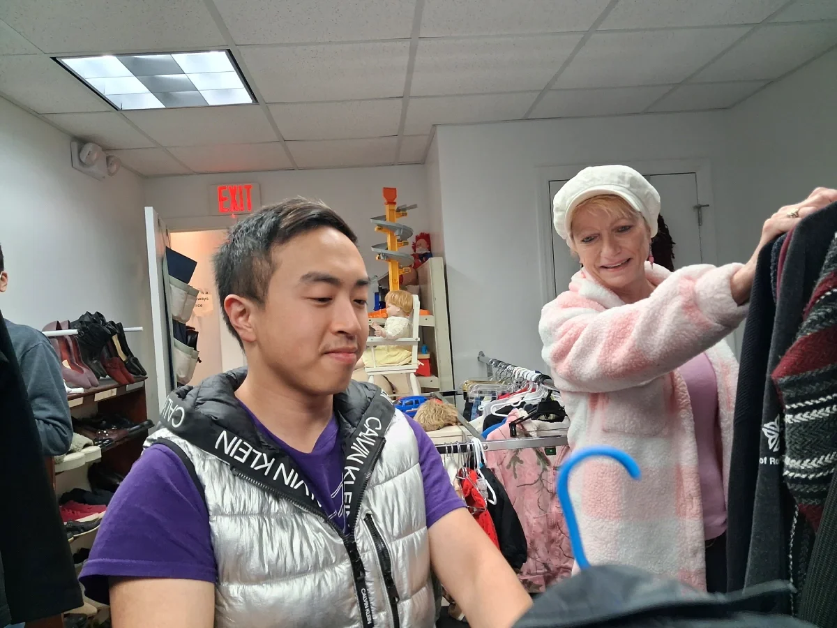 young man and woman with racks of clothing
