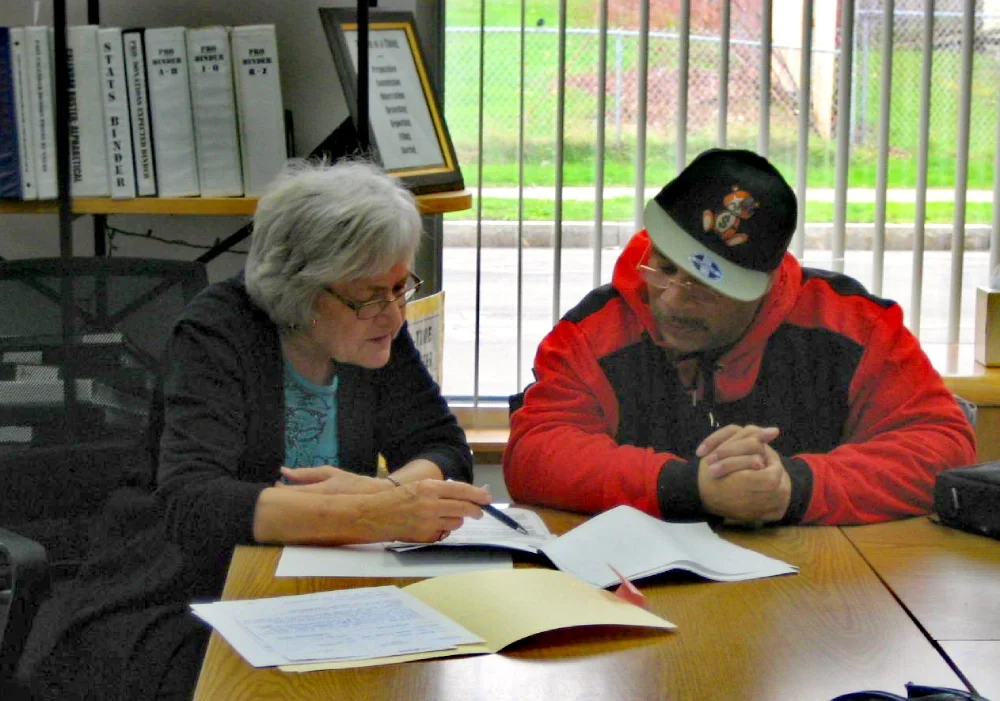 Volunteer reviewing paperwork with  a benefit recipient