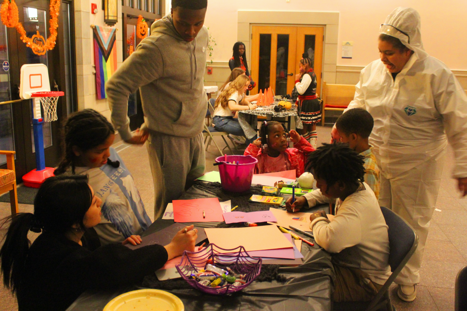 two adults with four children doing crafts at a Halloween Party