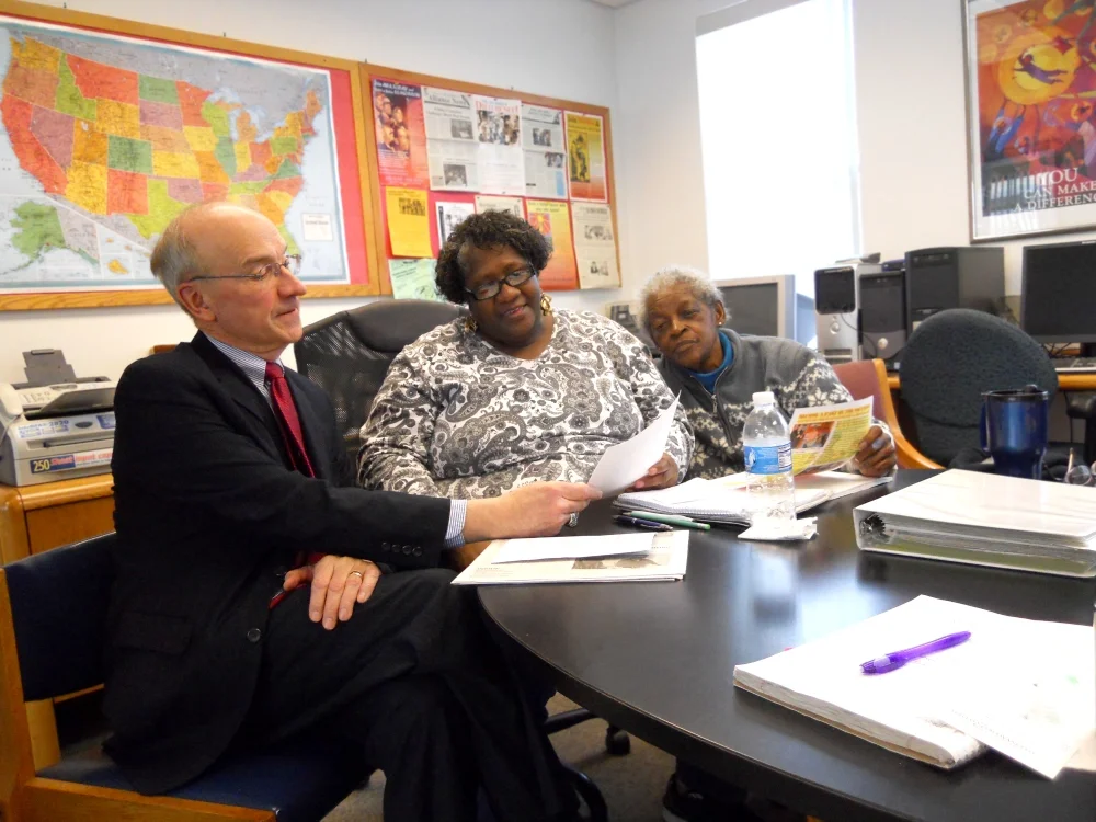 Attorney reading with two women at a legal session
