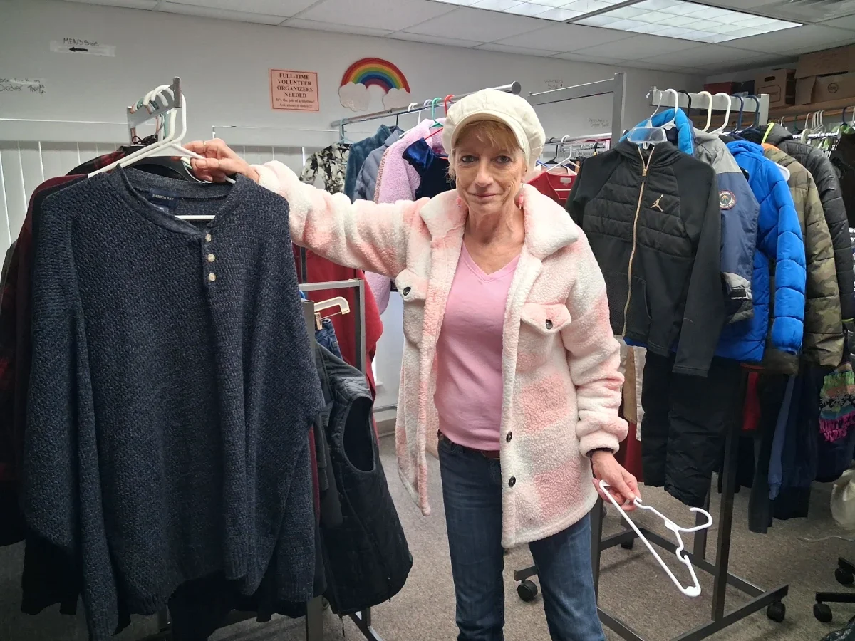 woman volunteer showing racks of clothing