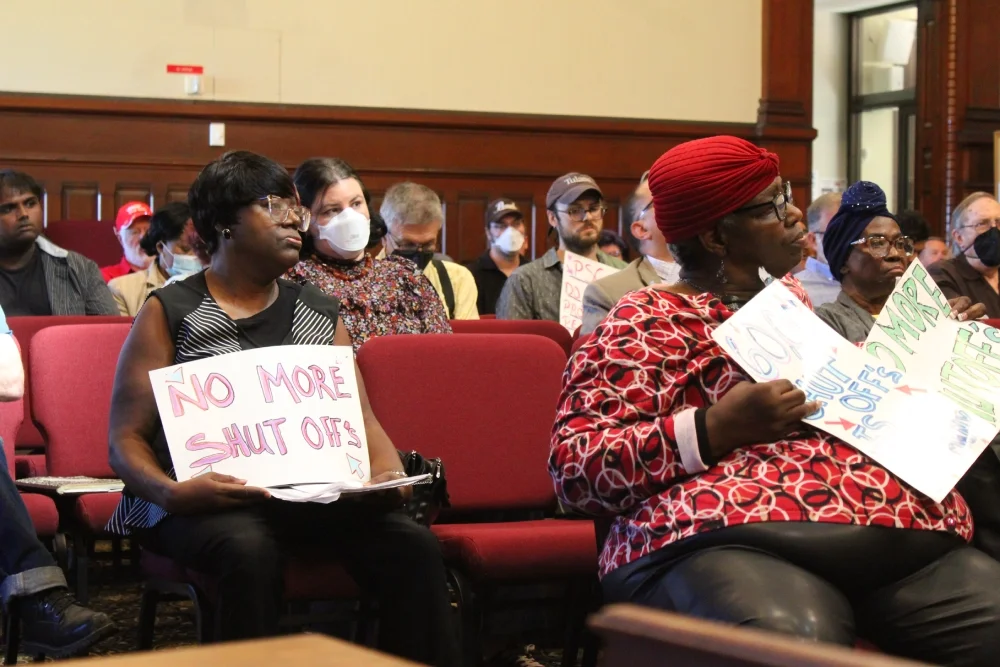 Hearing attendees holding signs