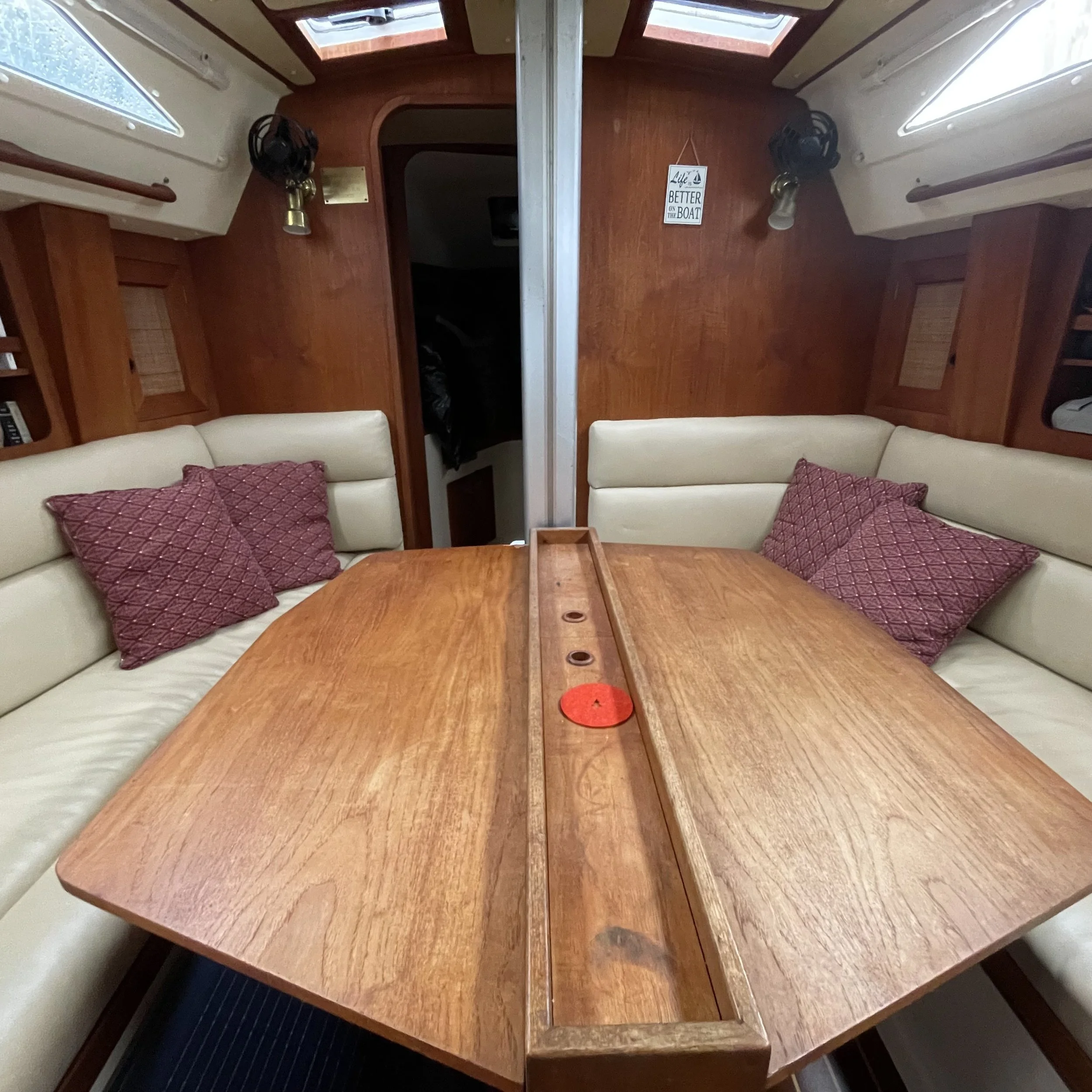 Dining table folds on both sides for room during passage. The center of the table has built in wine bottle compartments.