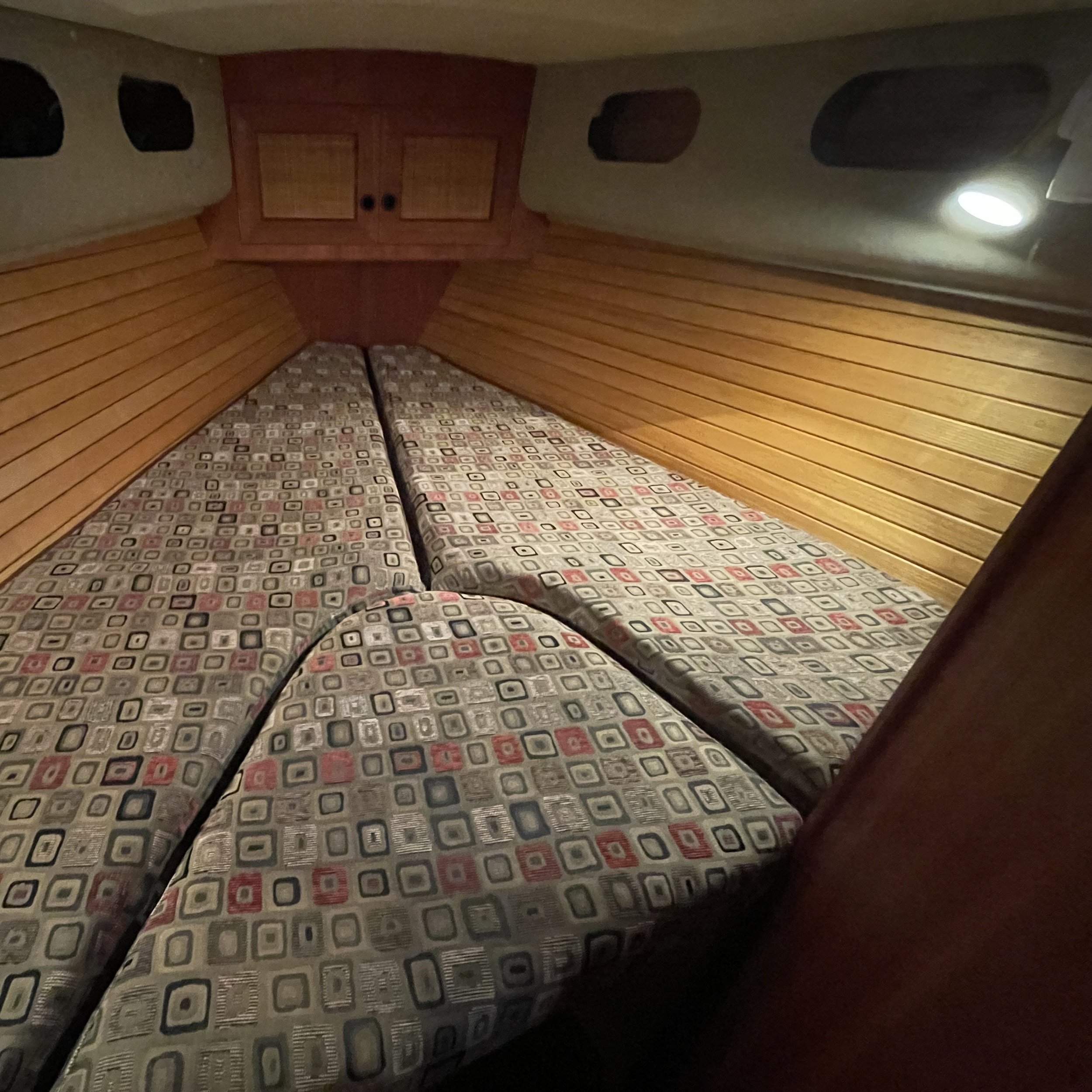 V-berth sleeps two with large foredeck hatch above for light and air.