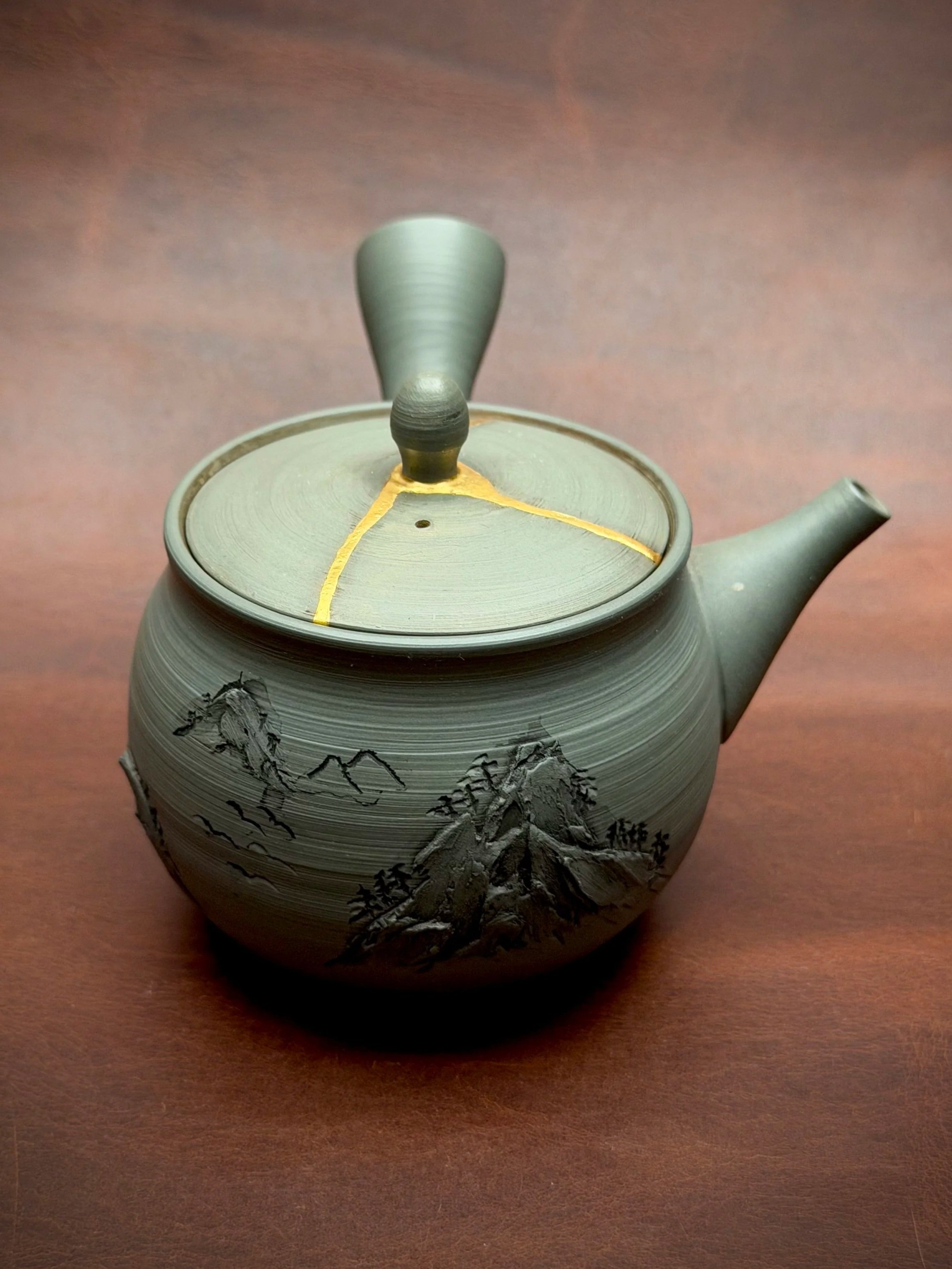 This kyūsu was purchased during a trip to Japan and later arrived in my studio after an accidental drop broke the lid.

One of my favorite details of this teapot is the relief-carved mountains. Combined with the soft green clay, it reminds me a littl