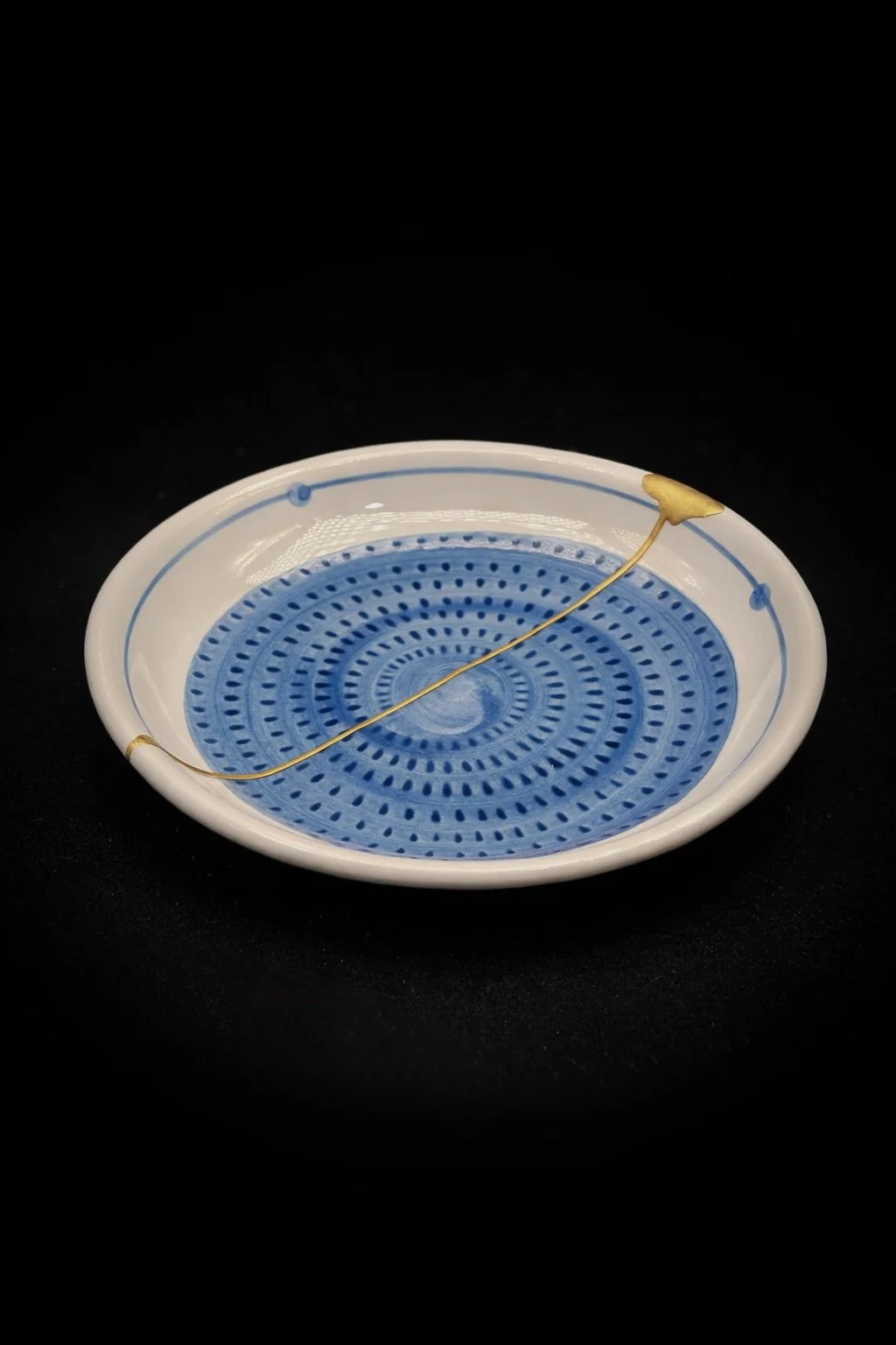 A well-loved little side plate. Traditionally, blue ceramics are often paired with silver in kintsugi repairs, since the colors complement each other so well. But the owner asked for gold to match their other pieces — and I have to say, I think it tu