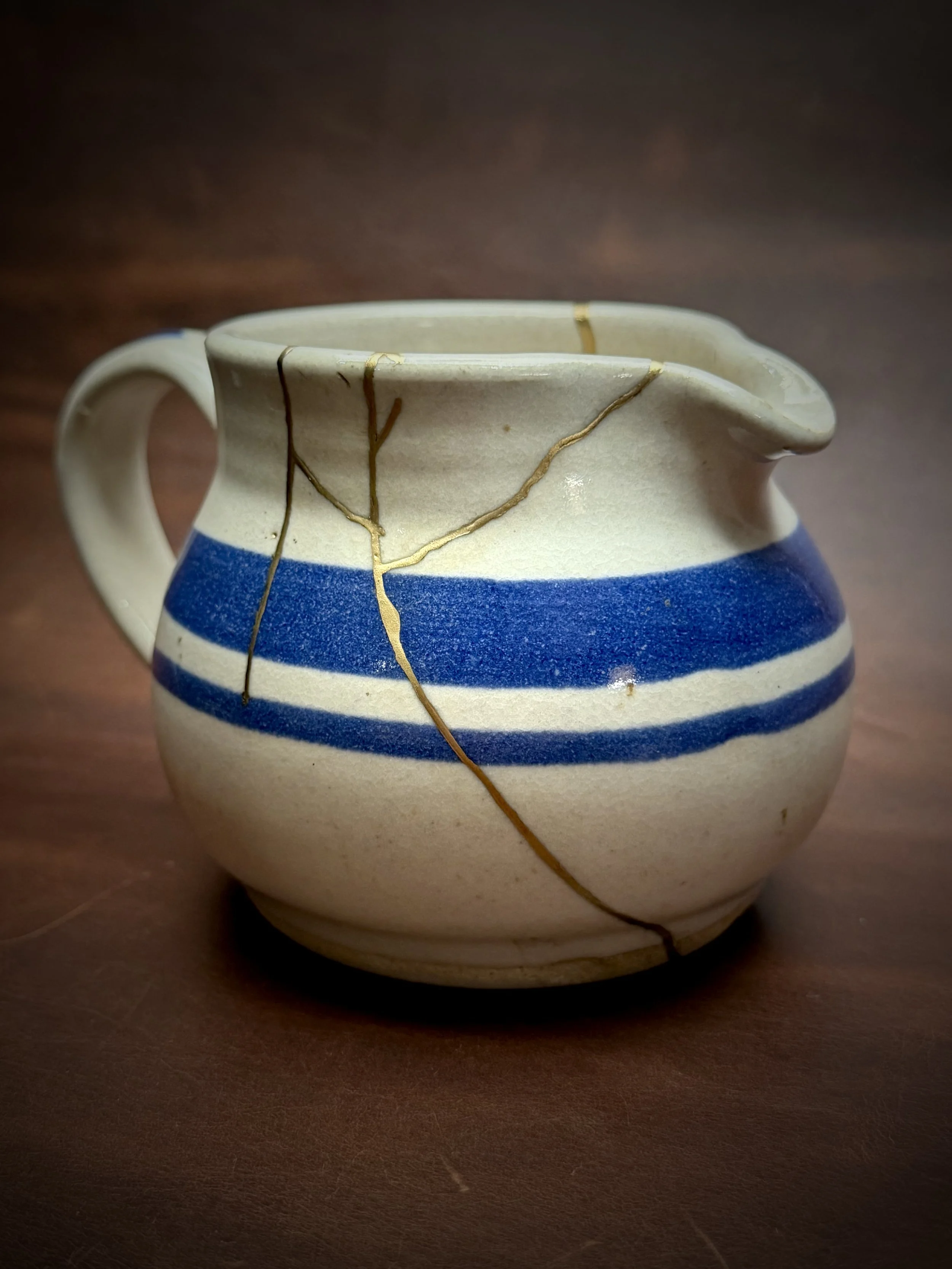 This small creamer arrived after an accidental fall left it broken into several pieces. Because the owner planned to display rather than use the piece, we opted for a bronze finish instead of a food-safe precious metal. The warmth of the bronze nicel