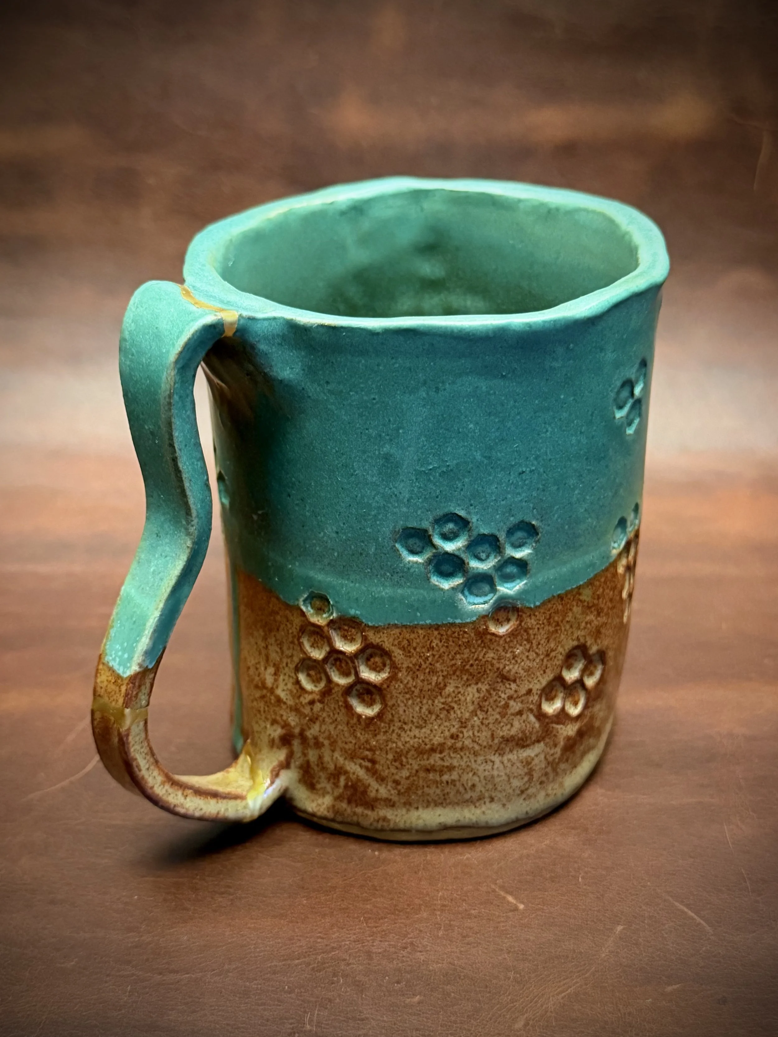This adorable mug was one of the very first pieces its owner made after she began taking pottery classes—which is honestly so impressive. I was immediately drawn to the bright turquoise glaze and the little stamped hexagon pattern.

The mug had alrea