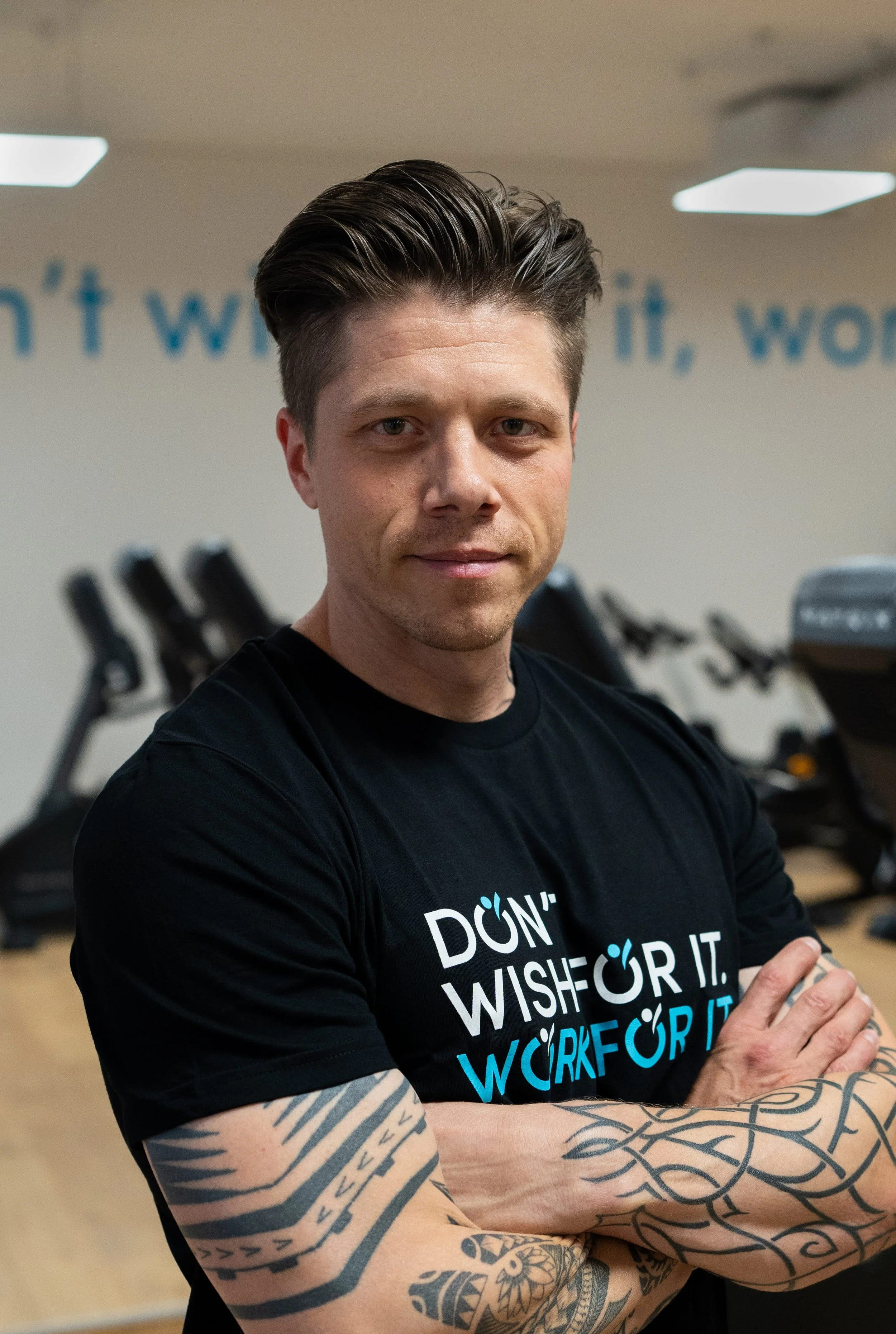 Roman Weber, zertifizierter Personal Trainer, Ernährungsberater und Fitness Coach für Männer und Frauen aus Bern (BE) Schweiz. Befindet sich gerade im Gym, Arme verschränkt.