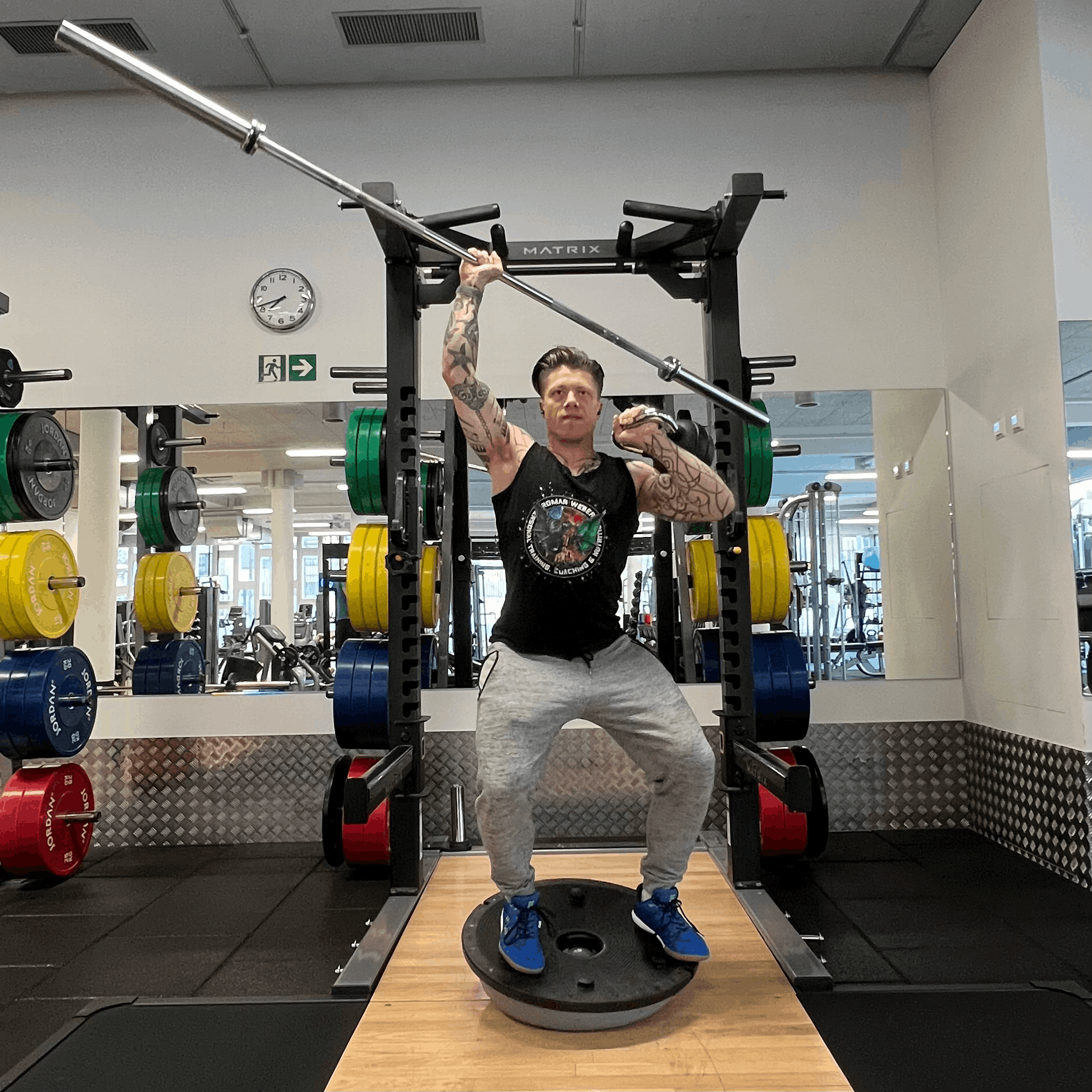 Roman Weber, Personal Trainer in Bern gerade im Gym, stämmt Gewichte