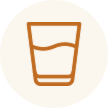 A glass of brown liquid, possibly tea or coffee, in a clear glass tumbler