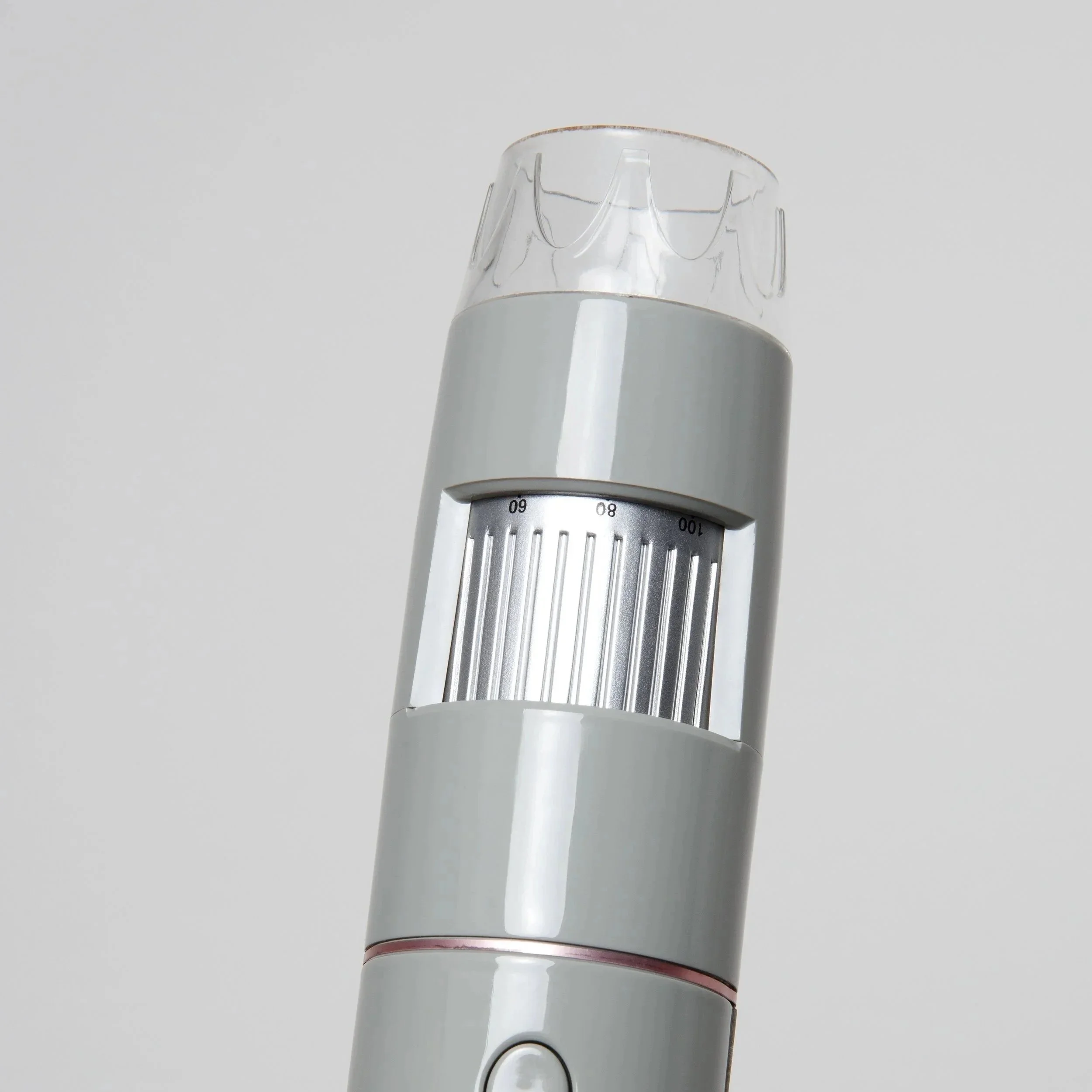 Close-up of a gray electronic device with a transparent plastic top and a dial with numbers, likely a medical instrument or a kitchen tool.