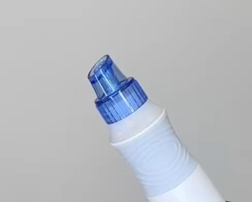 A close-up of a nasal spray bottle with a blue cap and nozzle.