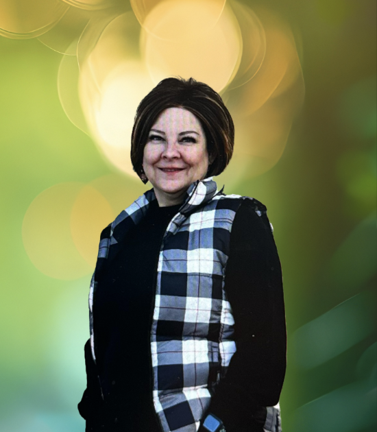 Woman standing, wearing a black and white plaid vest.