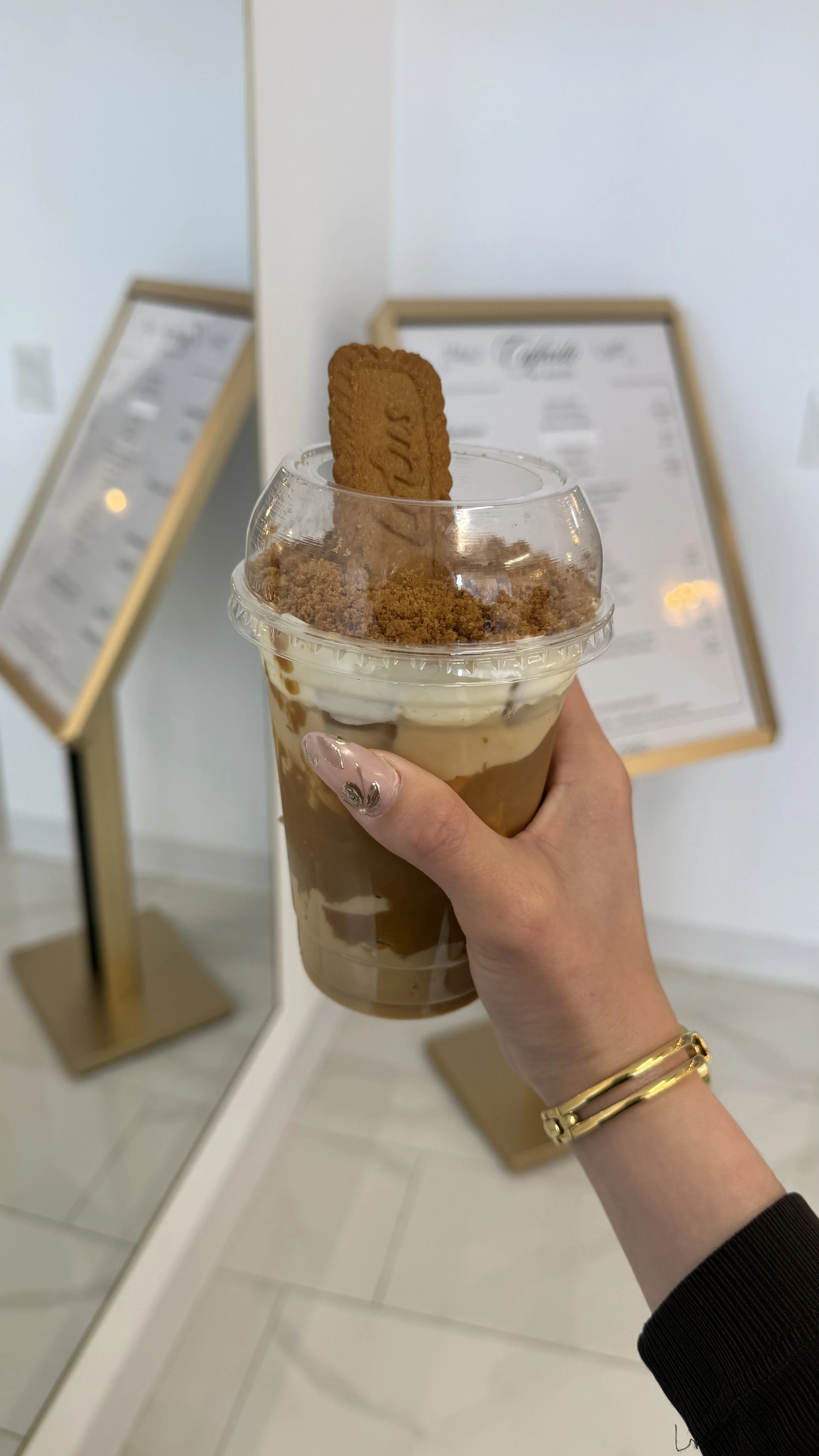 Hand holding a Biscoff cookie latte