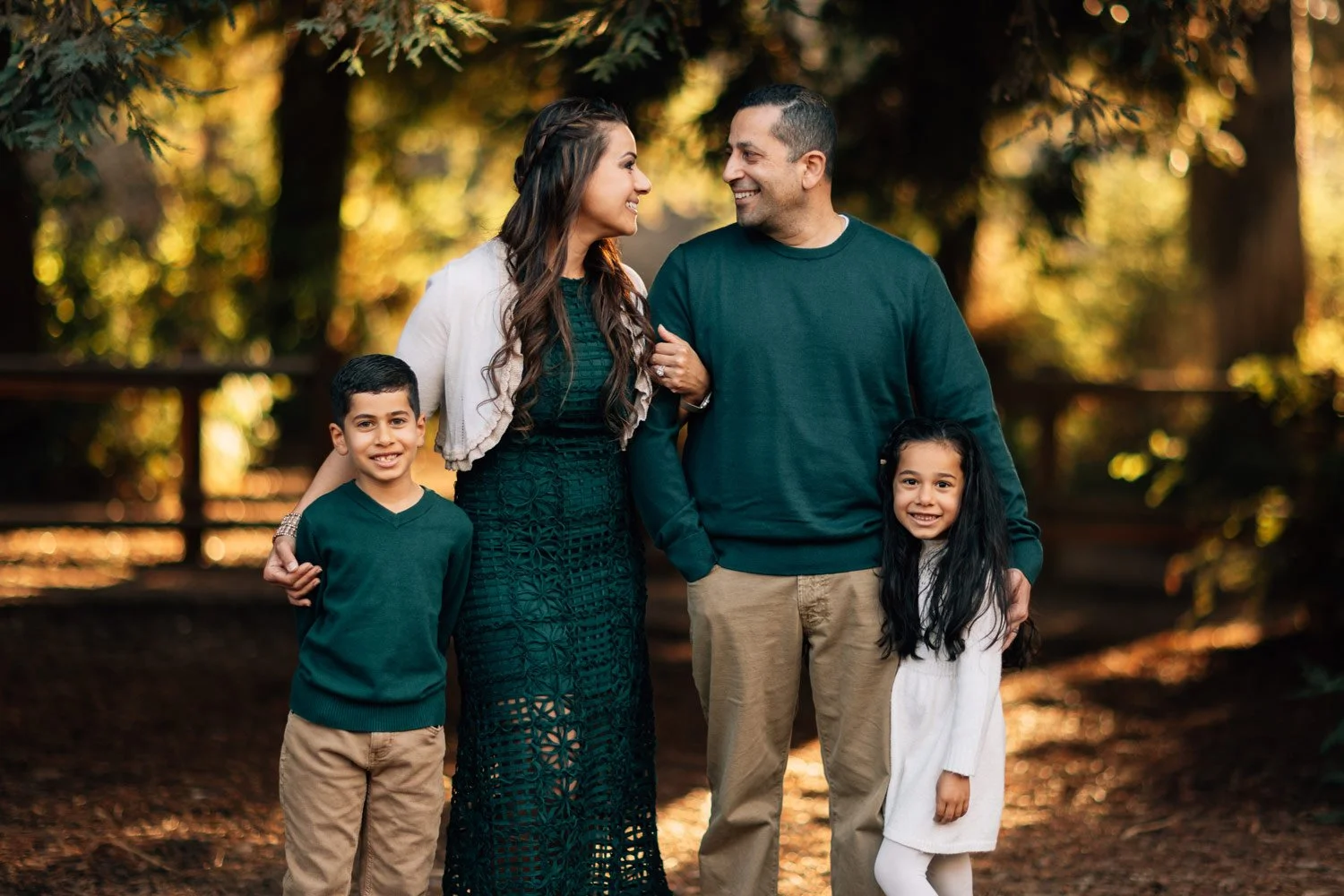 Smiling family at Carbon Canyon park posing for family portraits in front of the southern California Redwood trees