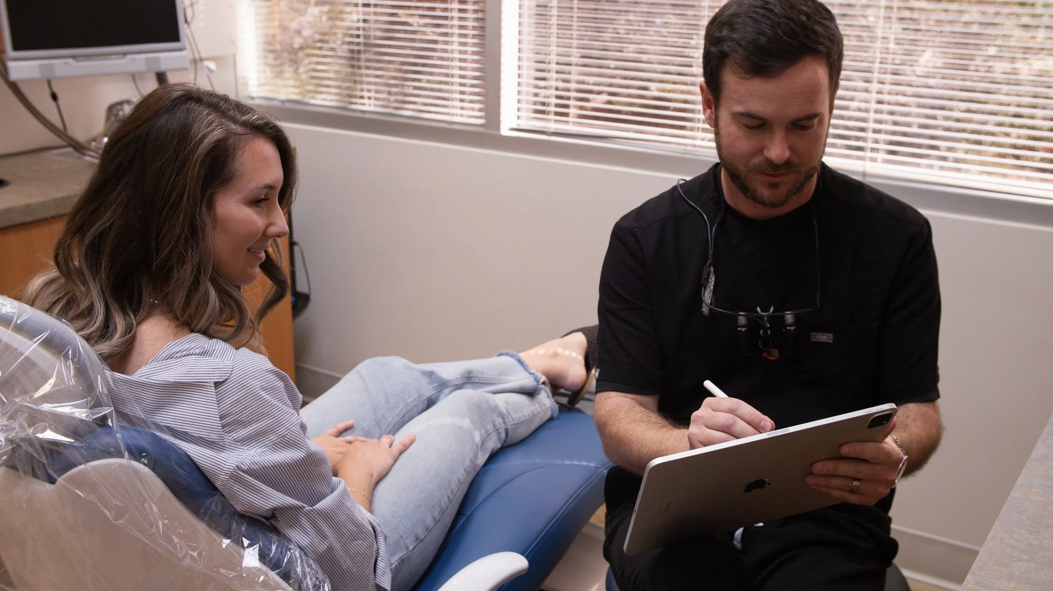 Phoenix prosthodontist Dr. Lassiter reviewing digital treatment plans with a patient during a consultation.