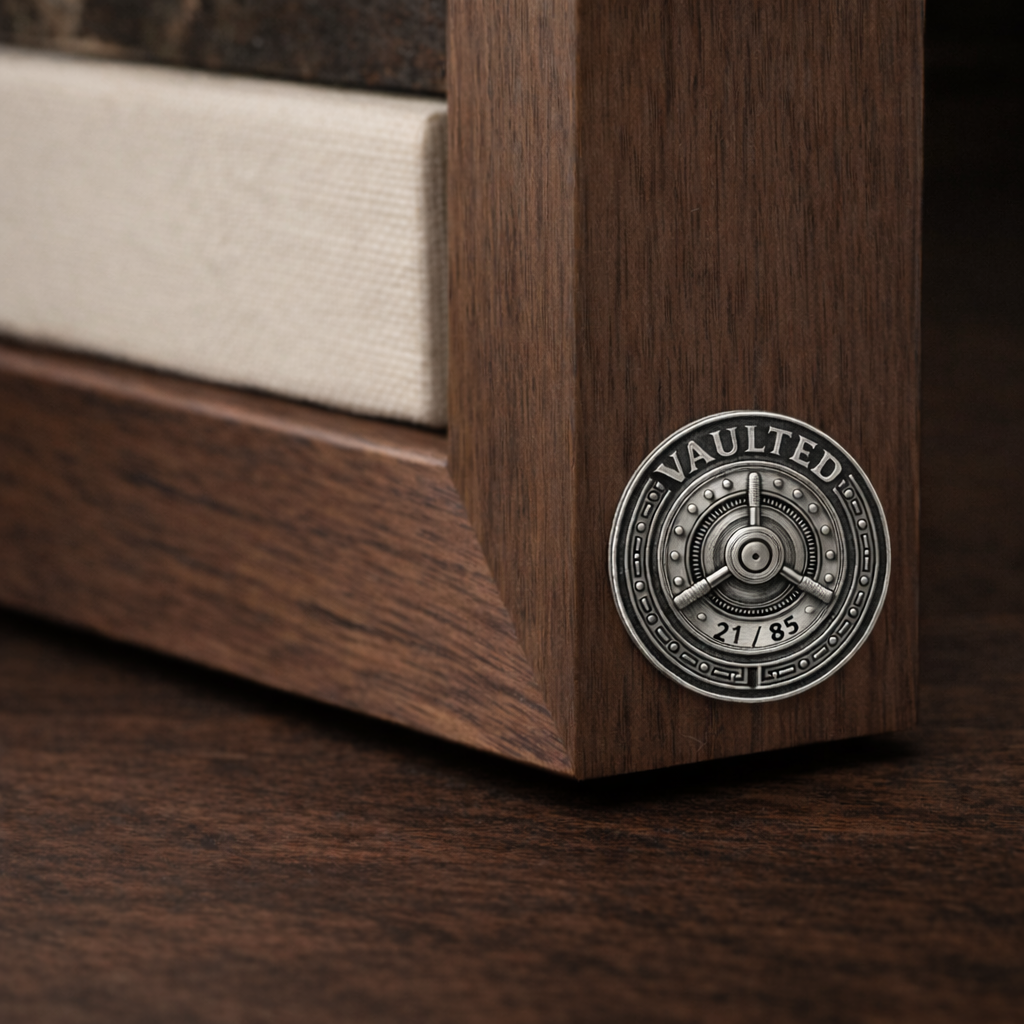 Close-up of a corner of a wooden bed frame with a metal vault lock on the side, and a beige fabric on the mattress.