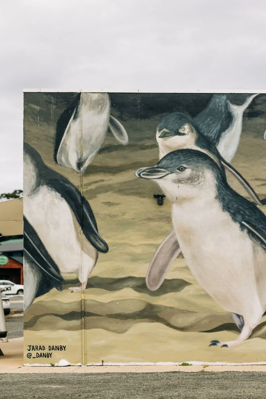 A portrait of a penguin on the side of a building. 