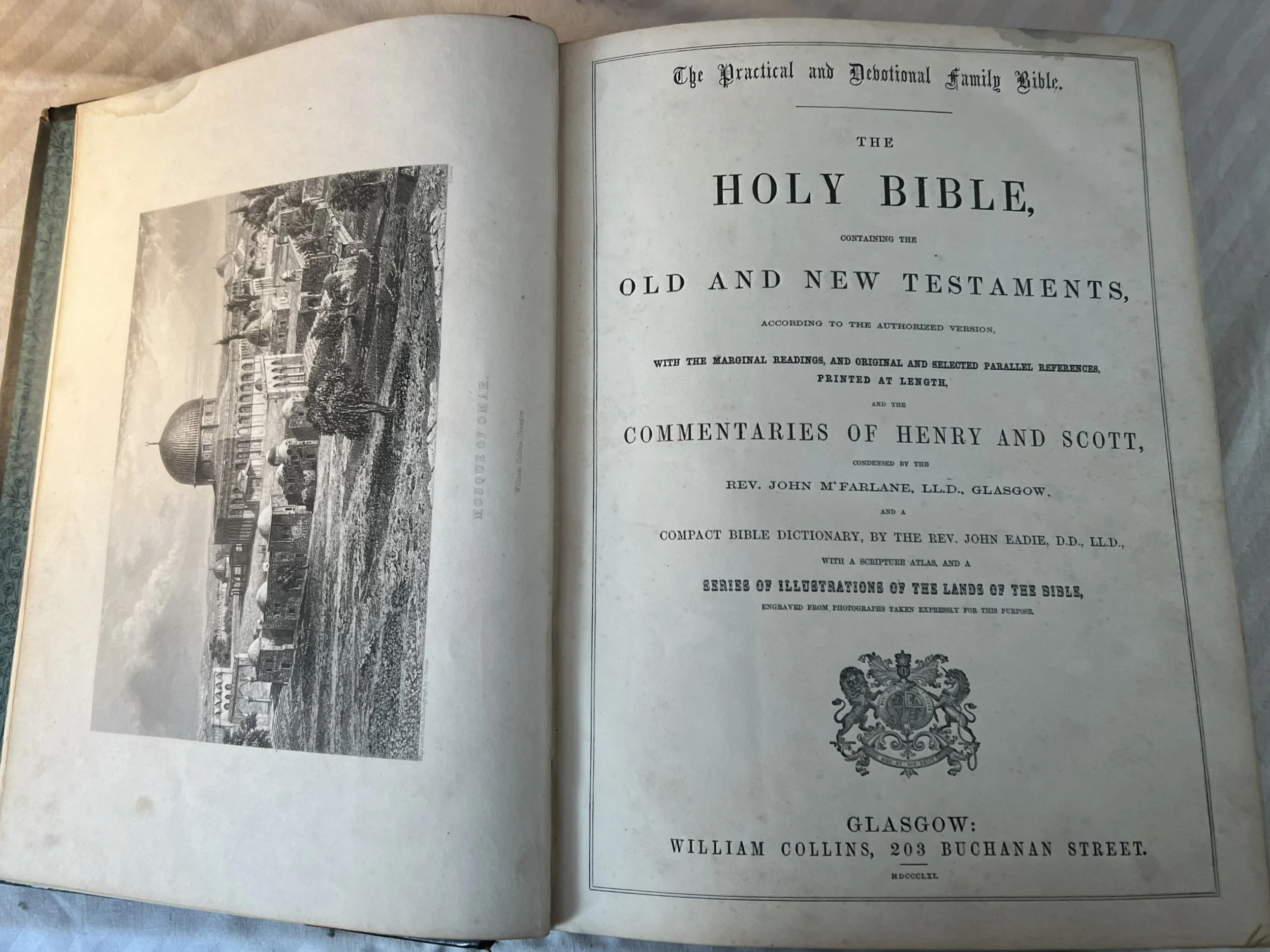 Open page of an old Bible featuring a black and white illustration of a church with a dome on the left, with ornate text on the right page outlining the title and publishing details of the Bible.