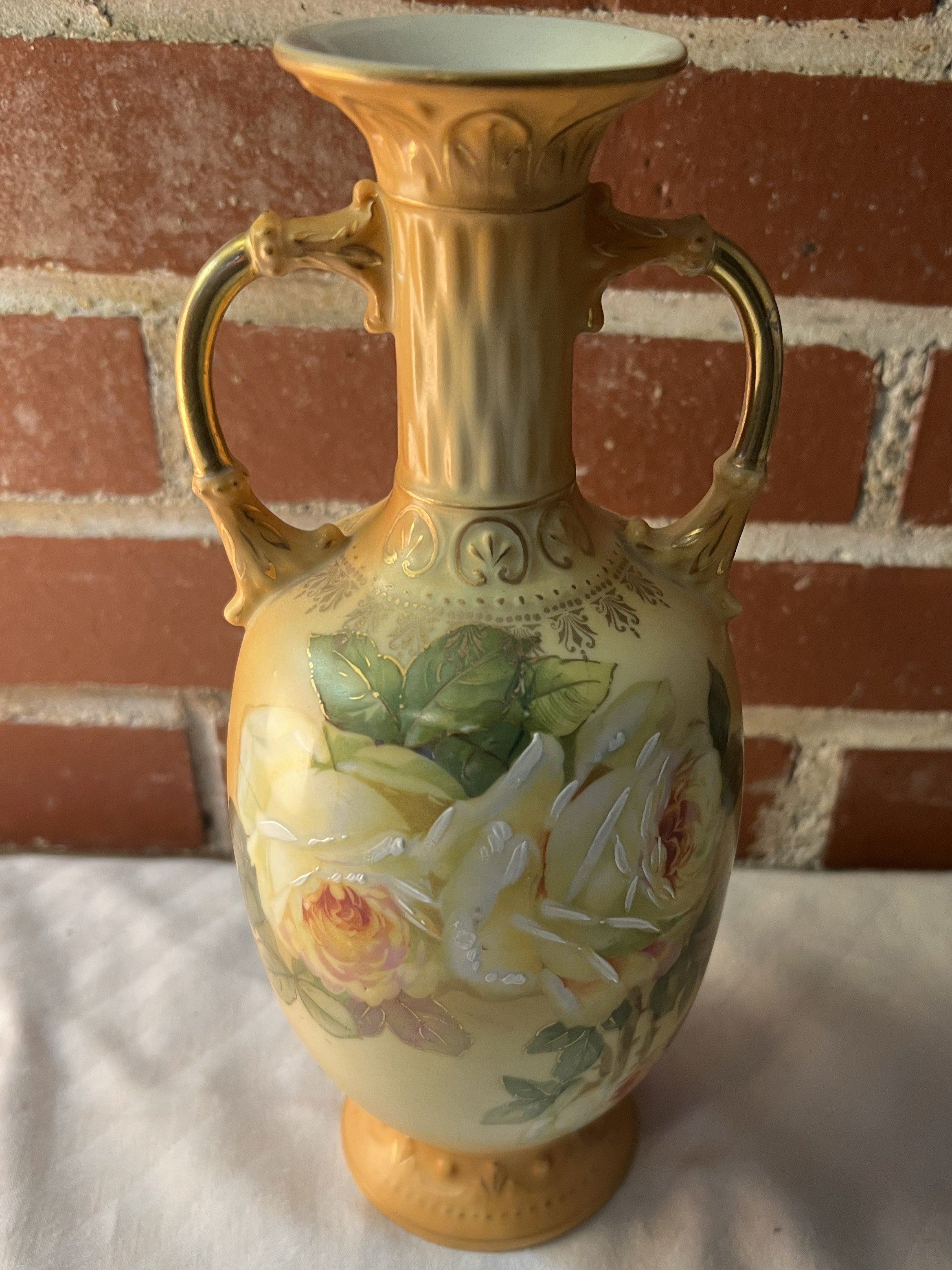 Antique Robert Hanke porcelain vase from Austria, featuring hand-painted yellow roses, gold gilded handles, and an Art Nouveau style. It is a highly decorative collectible piece often identified by its distinct floral motifs and gold accents. 