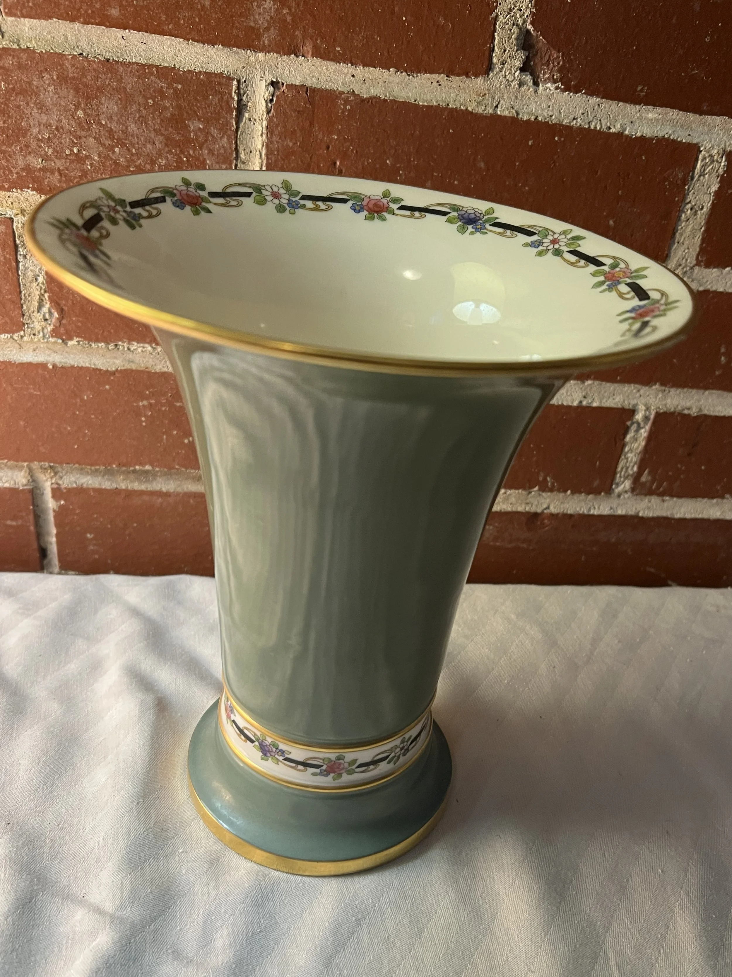 A decorative ceramic vase with floral patterns and gold trim
