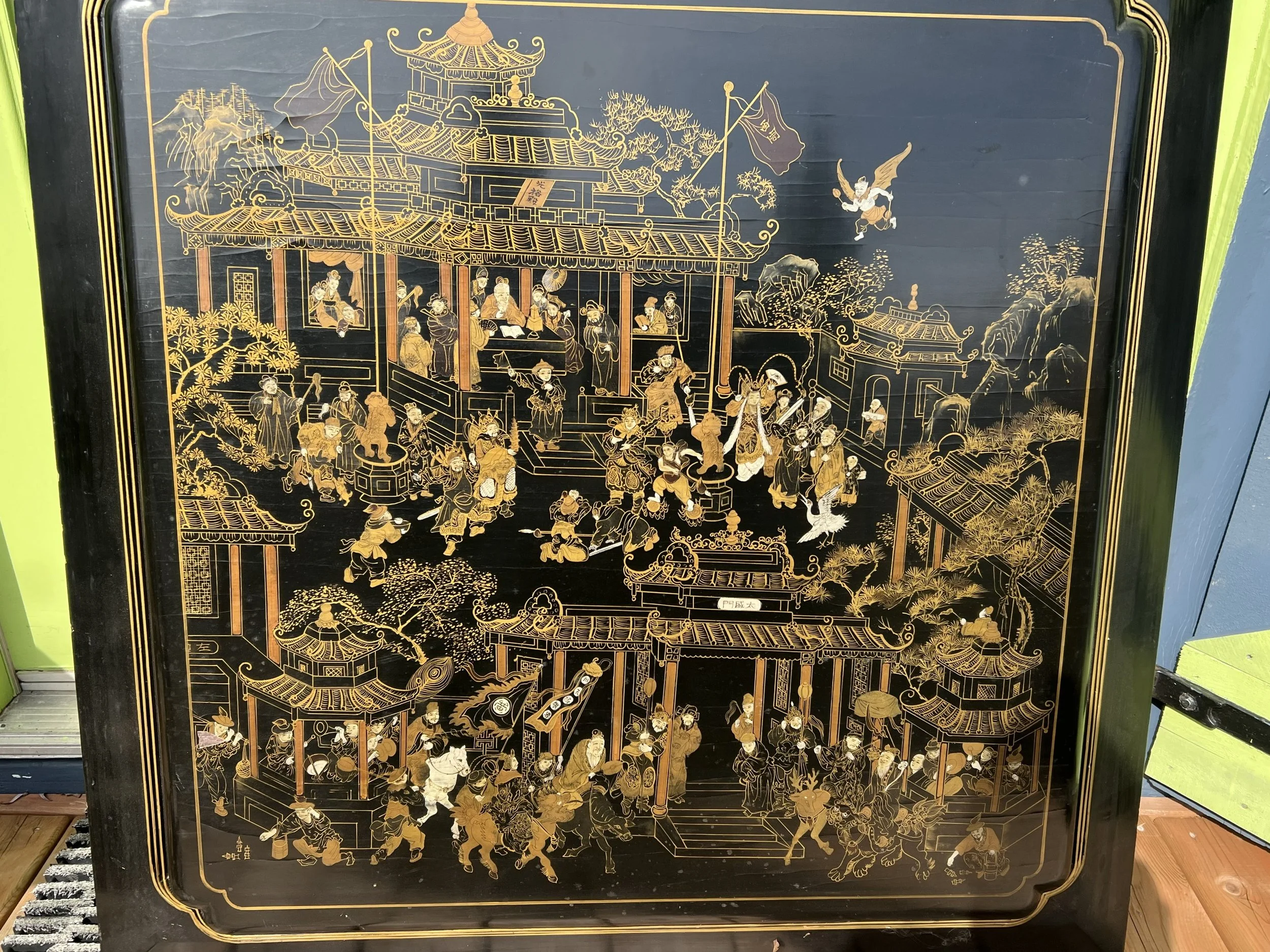 Chinese black and gold lacquer panel, a traditional form of decorative art often featuring intricate scenes of palaces, figures, and landscapes. These panels were popular as export items during the 18th and 19th centuries and continue to be produced 