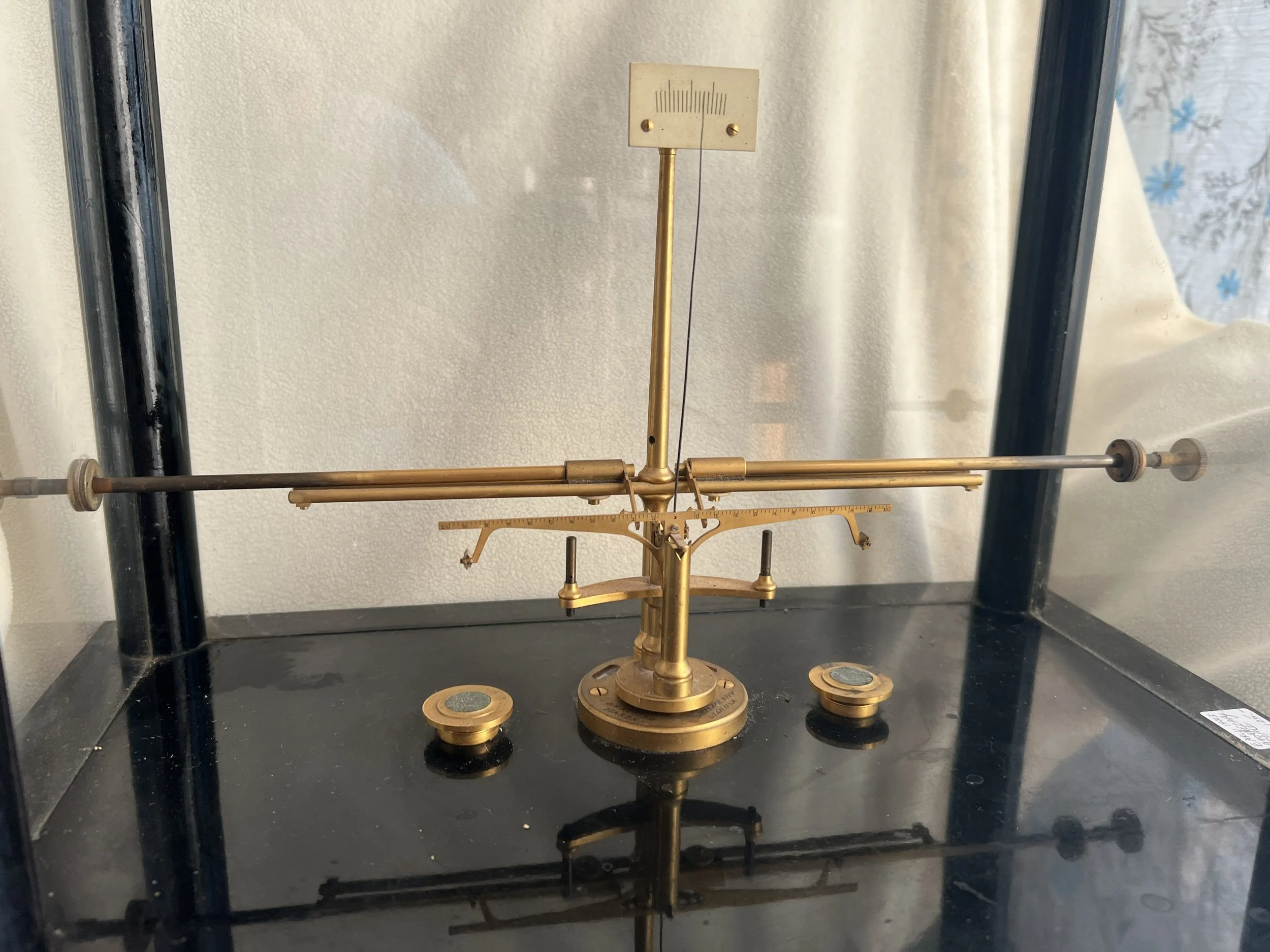Vintage brass scientific balance scale, likely an assay or pharmaceutical balance used for weighing precious metals or chemicals with high precision.   Mechanical beam balance designed for high accuracy.  Constructed primarily of brass with component