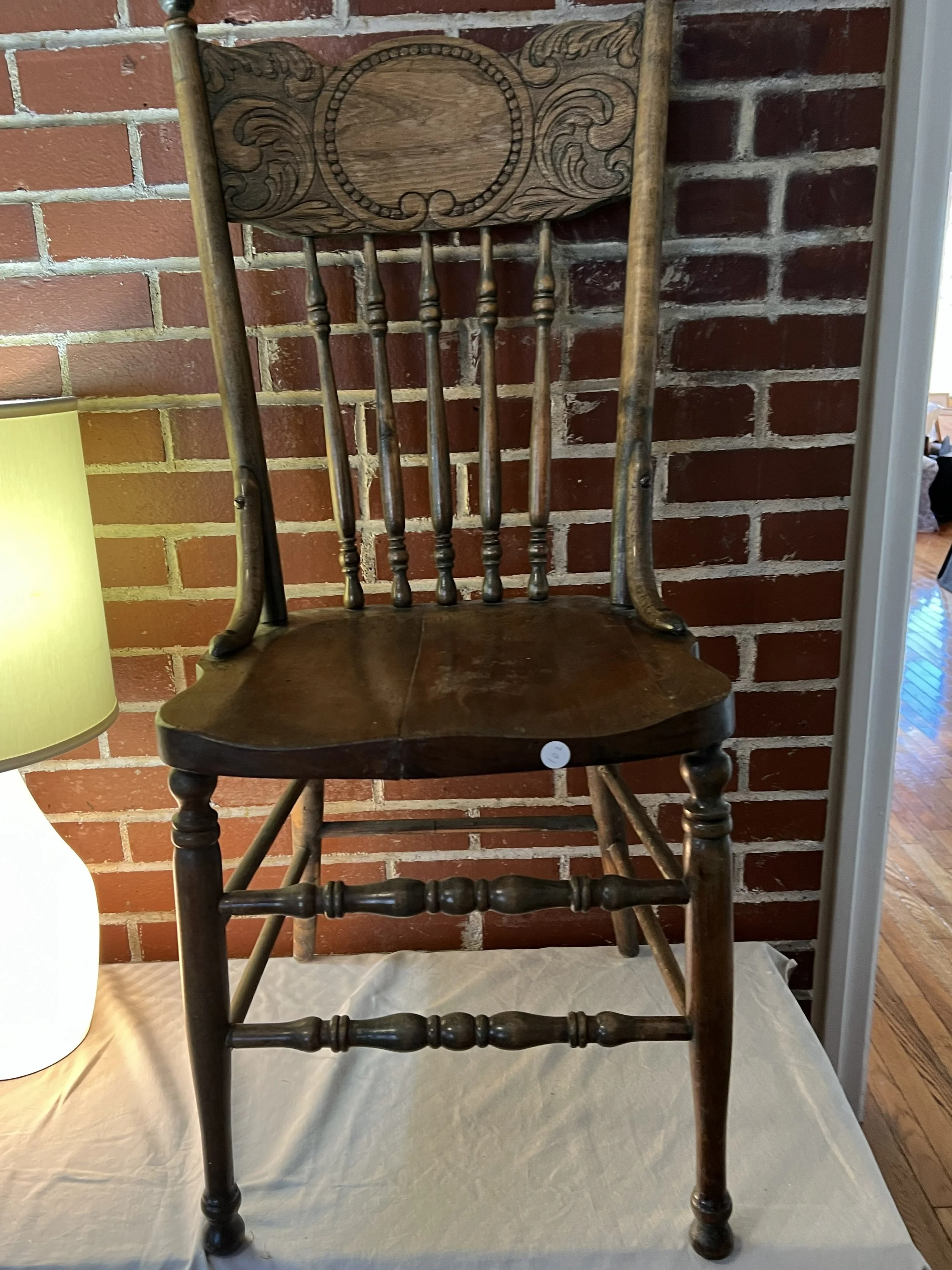 Antique pressed back wooden  chair with carved backrest.
